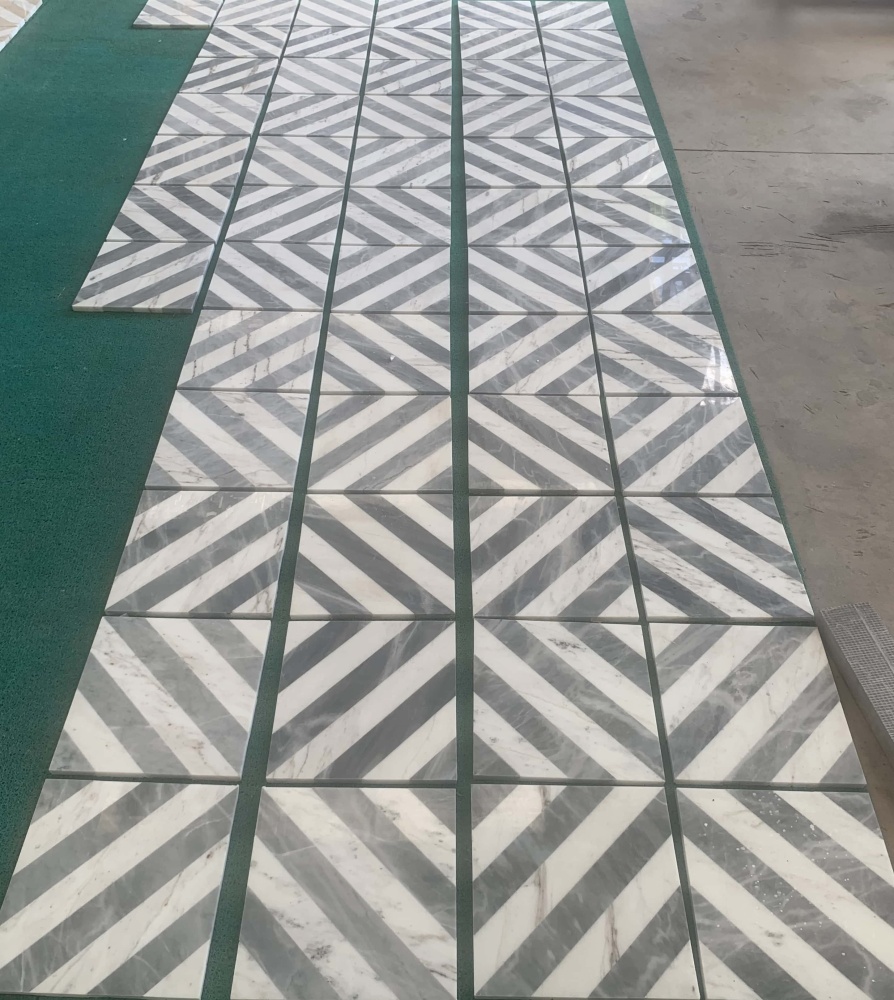 Seamless geometric zigzag design formed by the exclusive natural stone waterjet polished marble tiles.