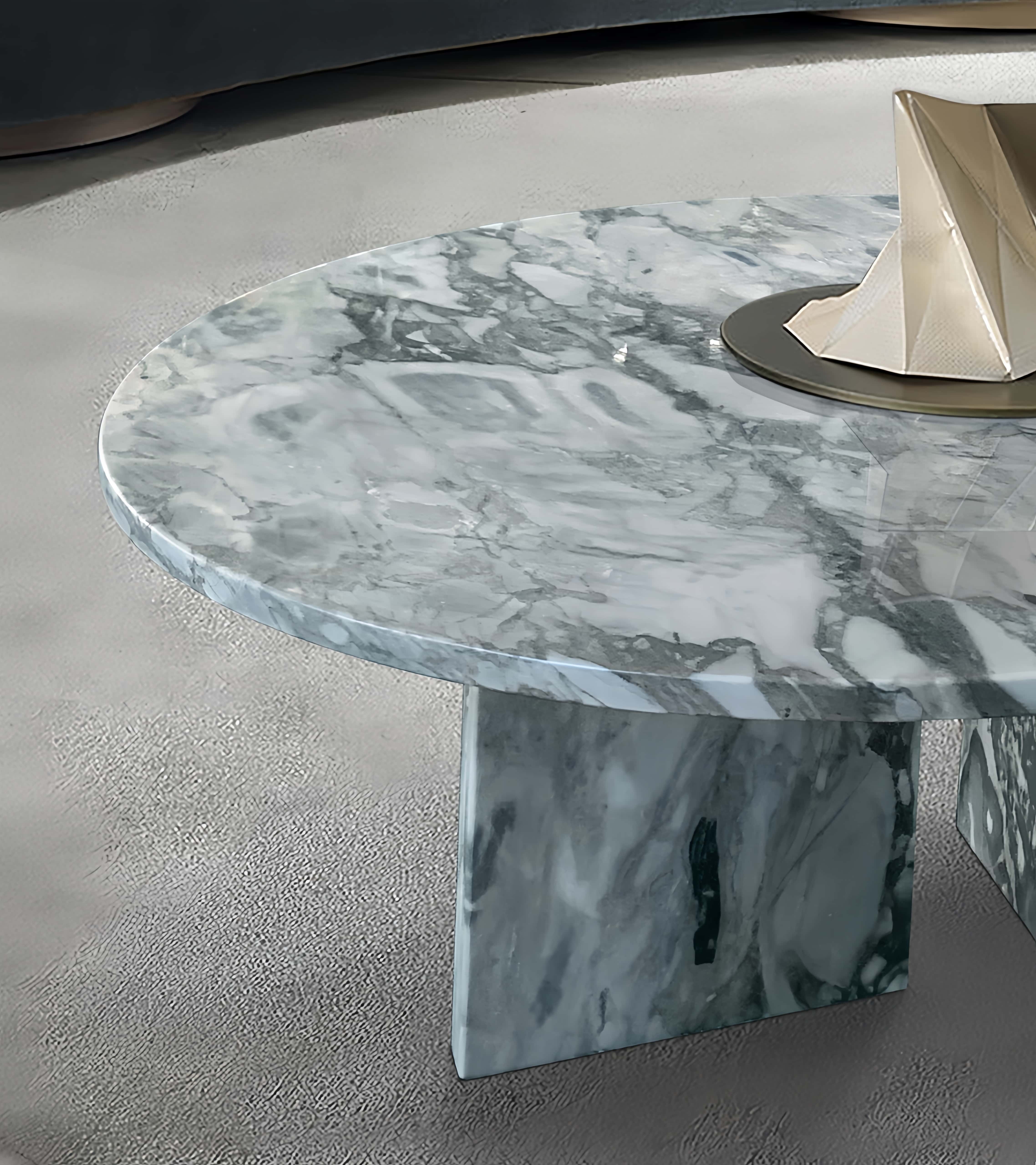 Close-up detail of the 70cm Cloudy Blue marble coffee table, showcasing the thick polished edge, striking geometric base, and 100% natural grey-blue veining.