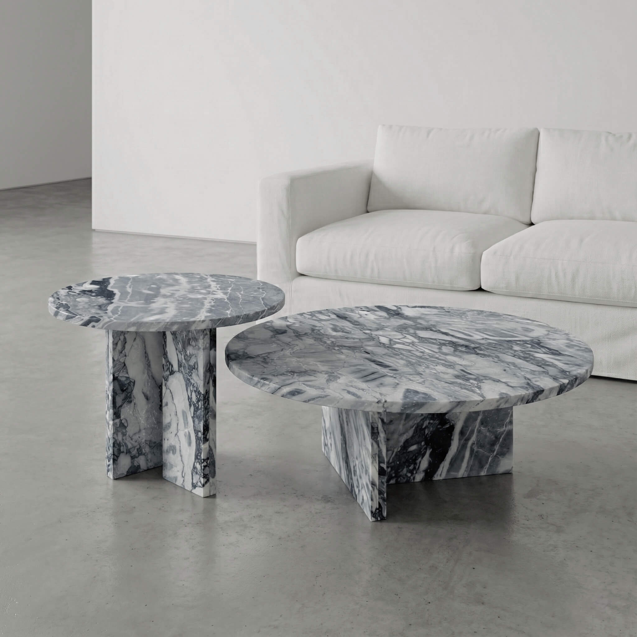 A luxury modern living room setting featuring the authentic Cloudy Blue natural marble nesting coffee table set as a stunning, one-of-a-kind centerpiece.