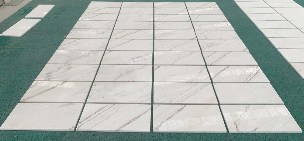 Large-scale factory floor layout of Snow Mountain White marble tiles ensuring consistent quality and natural vein matching.