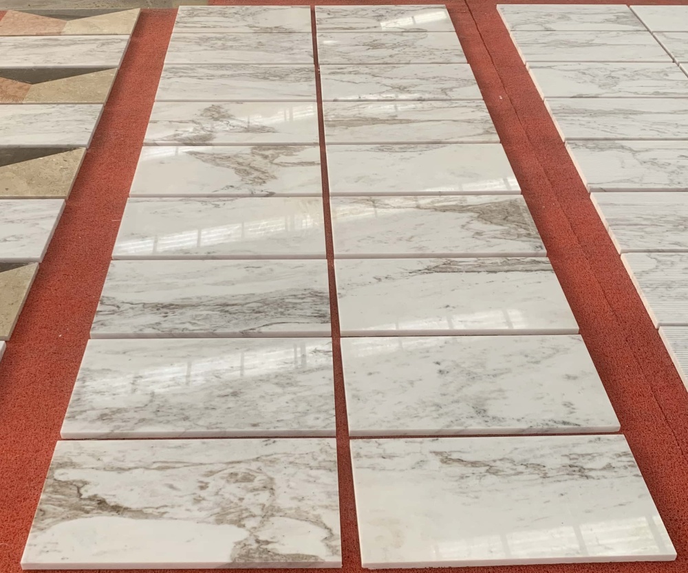 A collection of Snow Mountain White marble tiles showcasing the 100% unique natural stone artistry and grey textures.
