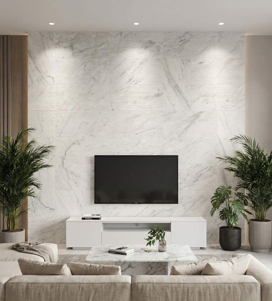Contemporary living room featuring a stunning TV accent wall clad in 12x24 Snow Mountain White textured natural marble tiles with linear grooves.
