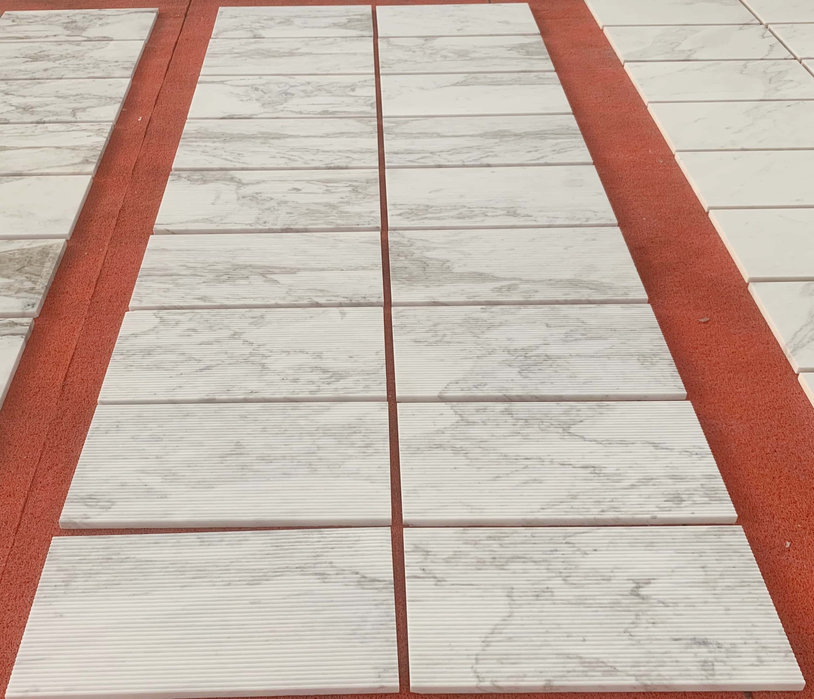 Large scale layout of natural Snow Mountain White marble tiles showing natural stone consistency and organic veining.