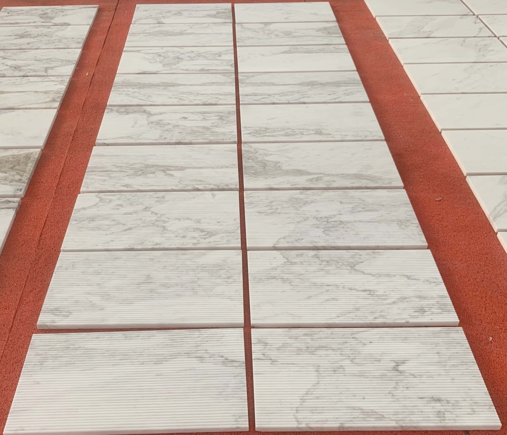 Large scale layout of natural Snow Mountain White marble tiles showing natural stone consistency and organic veining.