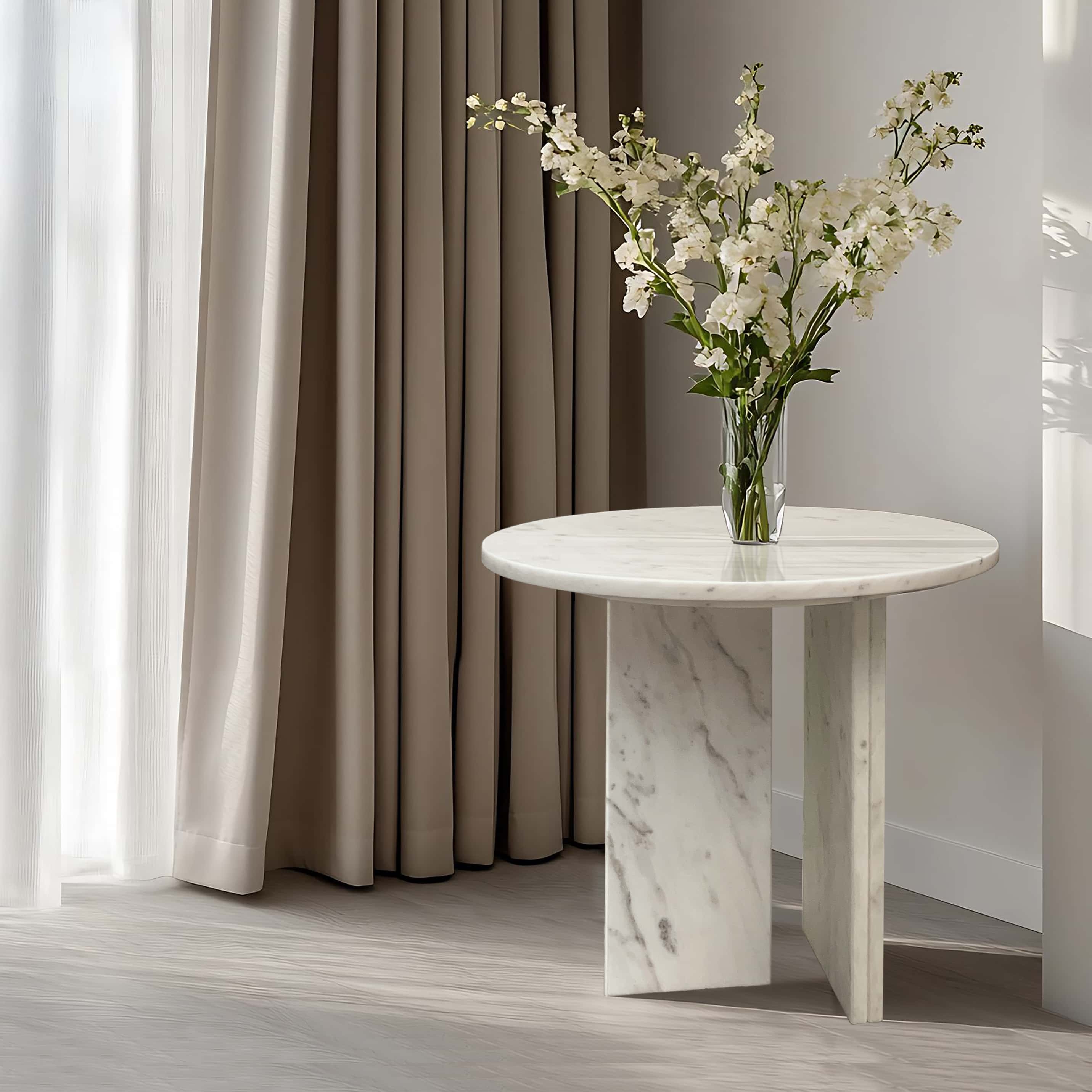 Elegant white natural marble coffee table styled with white flowers in a modern minimalist living room setting, serving as a stunning luxury centerpiece.