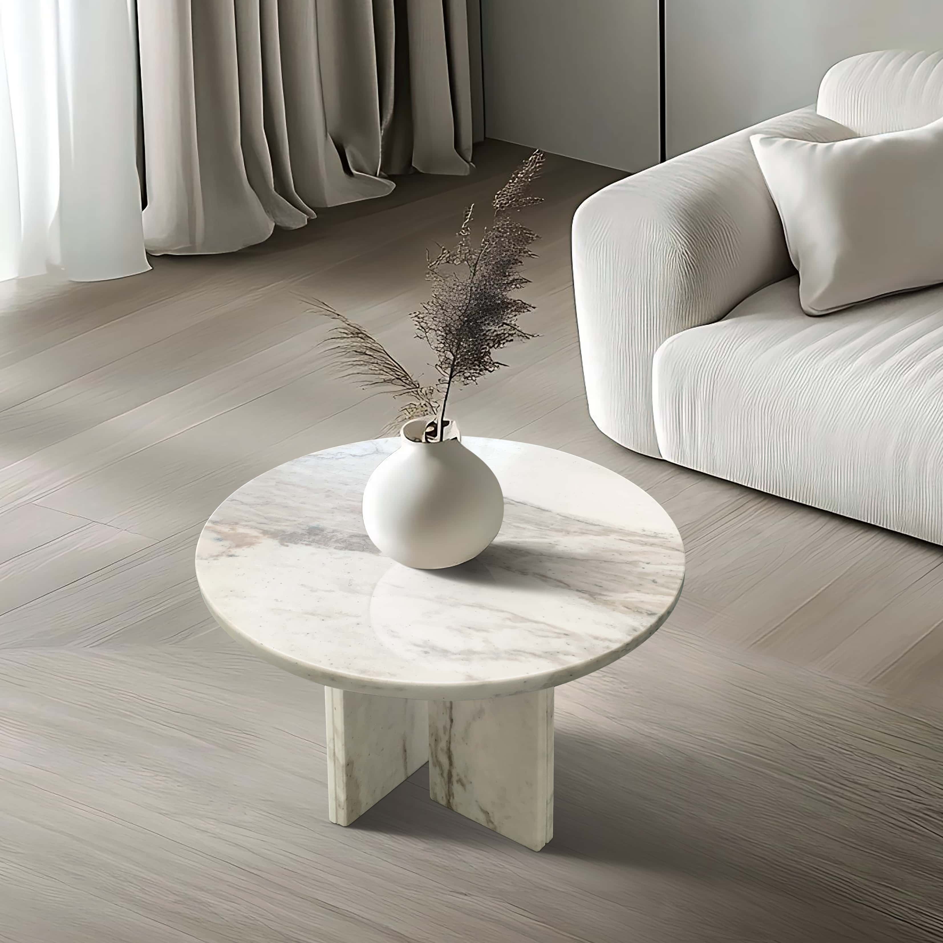 Minimalist luxury round marble coffee table placed next to a modern white sofa, demonstrating its versatile design for dynamic home décor.