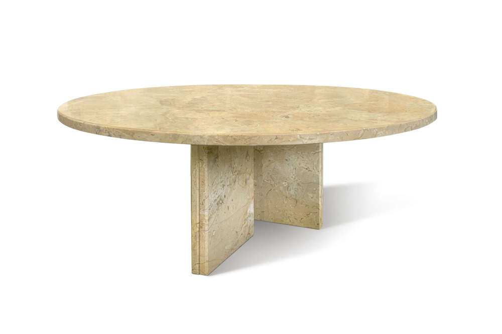 Angled view of the elegant yellow beige natural marble center table, highlighting its smooth round top and sturdy geometric stone legs.