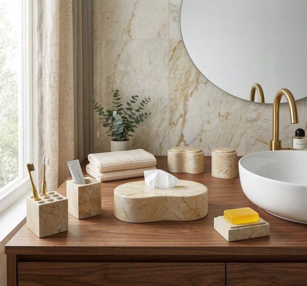 Organic modern bathroom design showcasing the Hyatt Gold natural stone accessories set on a rich walnut wood vanity next to a white vessel sink. Easily elevate your space with these unique, unrepeatable marble pieces. In stock in the US.