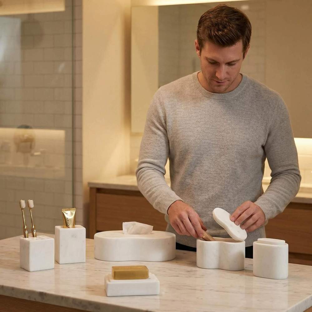 A man interacting with the lidded natural marble decorative box from the Snow Mountain White bathroom vanity set on a luxurious bathroom countertop.