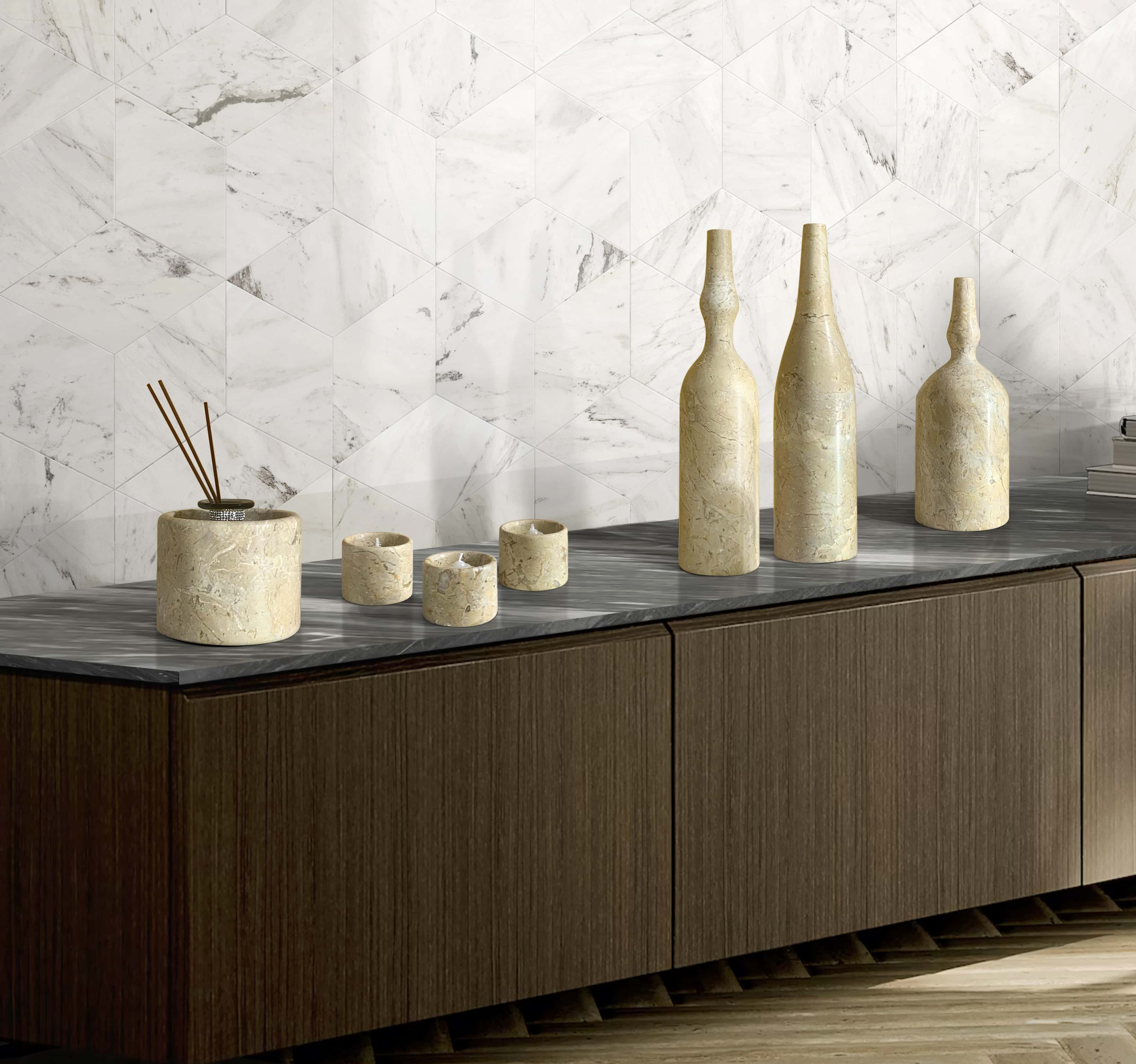 Close-up view of the 100% genuine Hyatt Gold honed marble vase and candle holder set, beautifully styled against a striking Snow Mountain White polished hexagon marble tile backdrop.