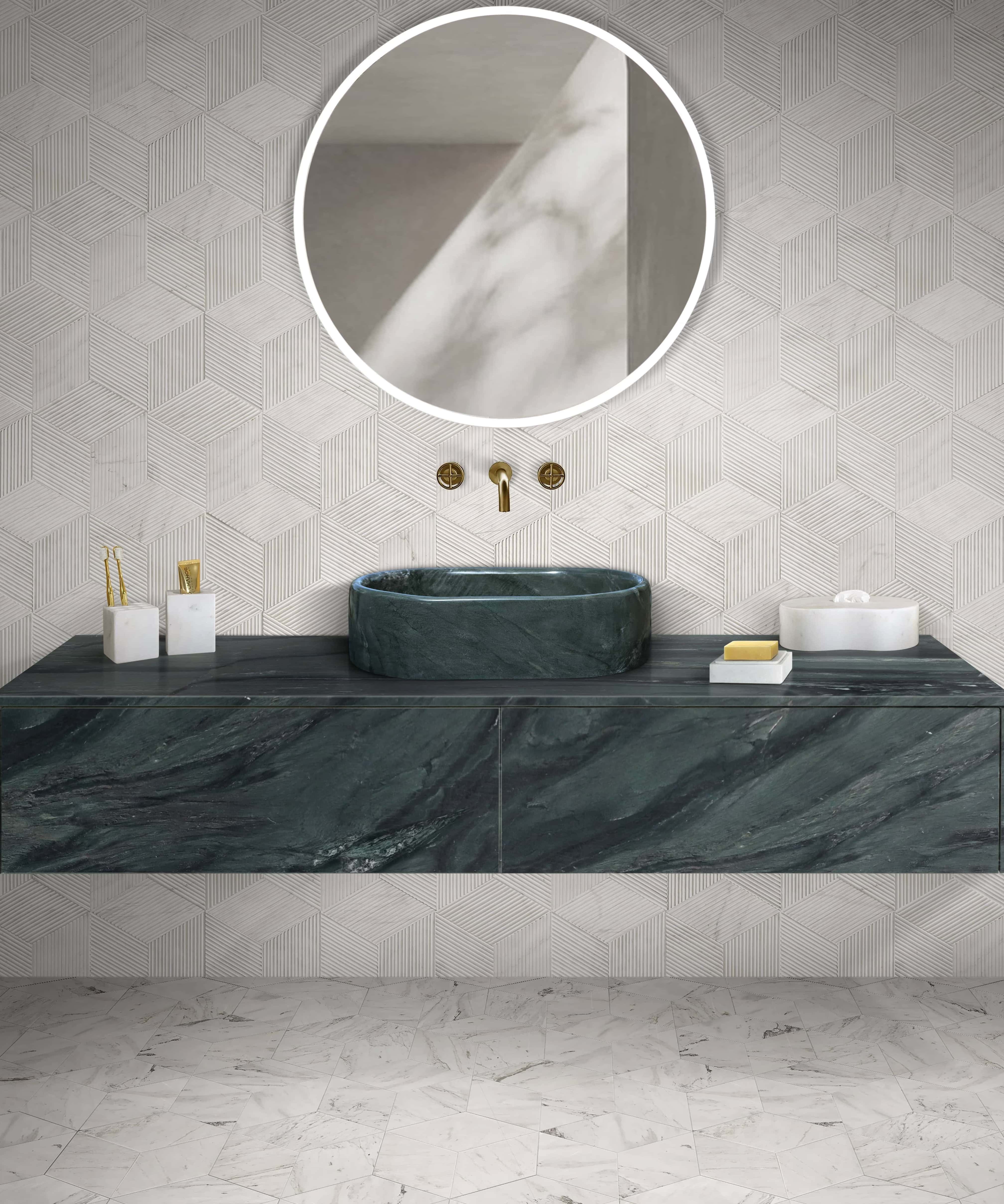 Modern bathroom setup featuring a green natural marble oval sink paired with a wall-mounted gold faucet. The space is accented by Snow Mountain White hexagon textured wall tiles and matching polished hexagon floor tiles.