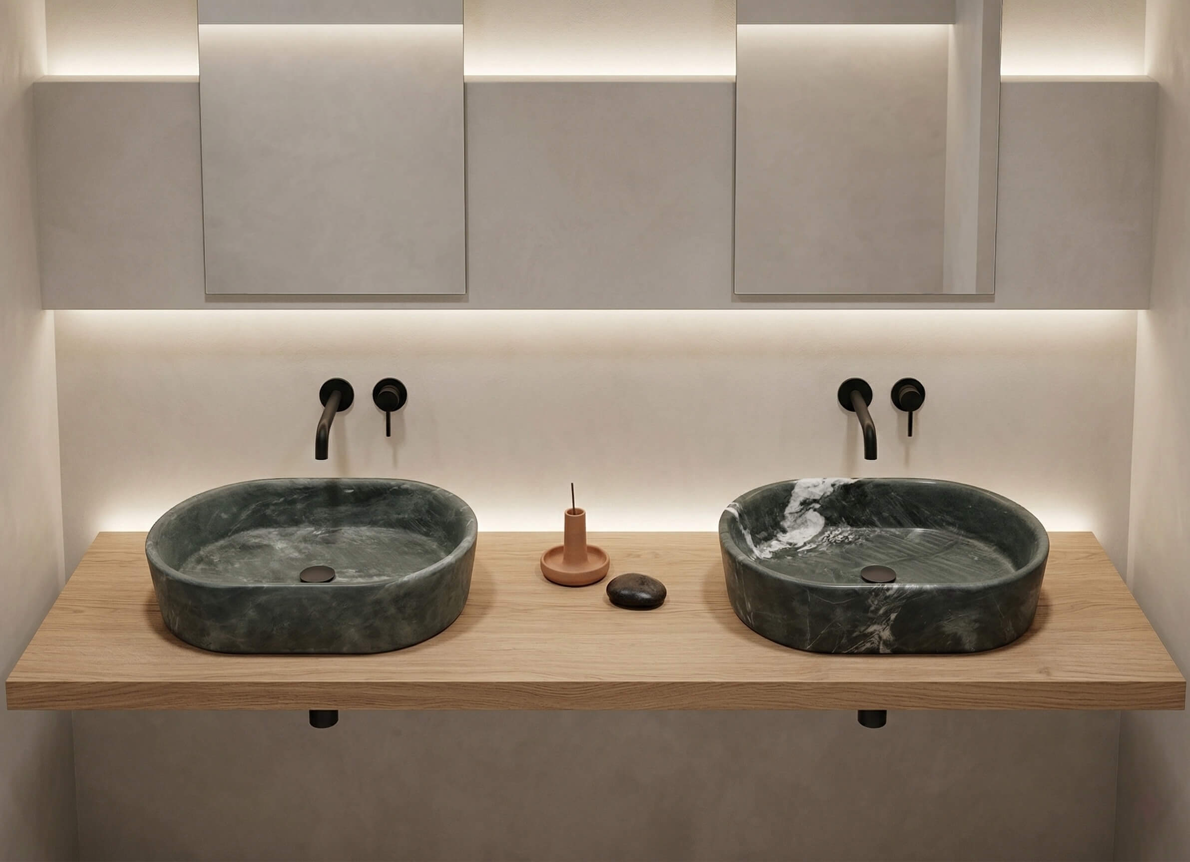 Two oval green natural marble vessel sinks resting on a wooden double vanity top, paired with wall-mounted metal faucets below rectangular mirrors.