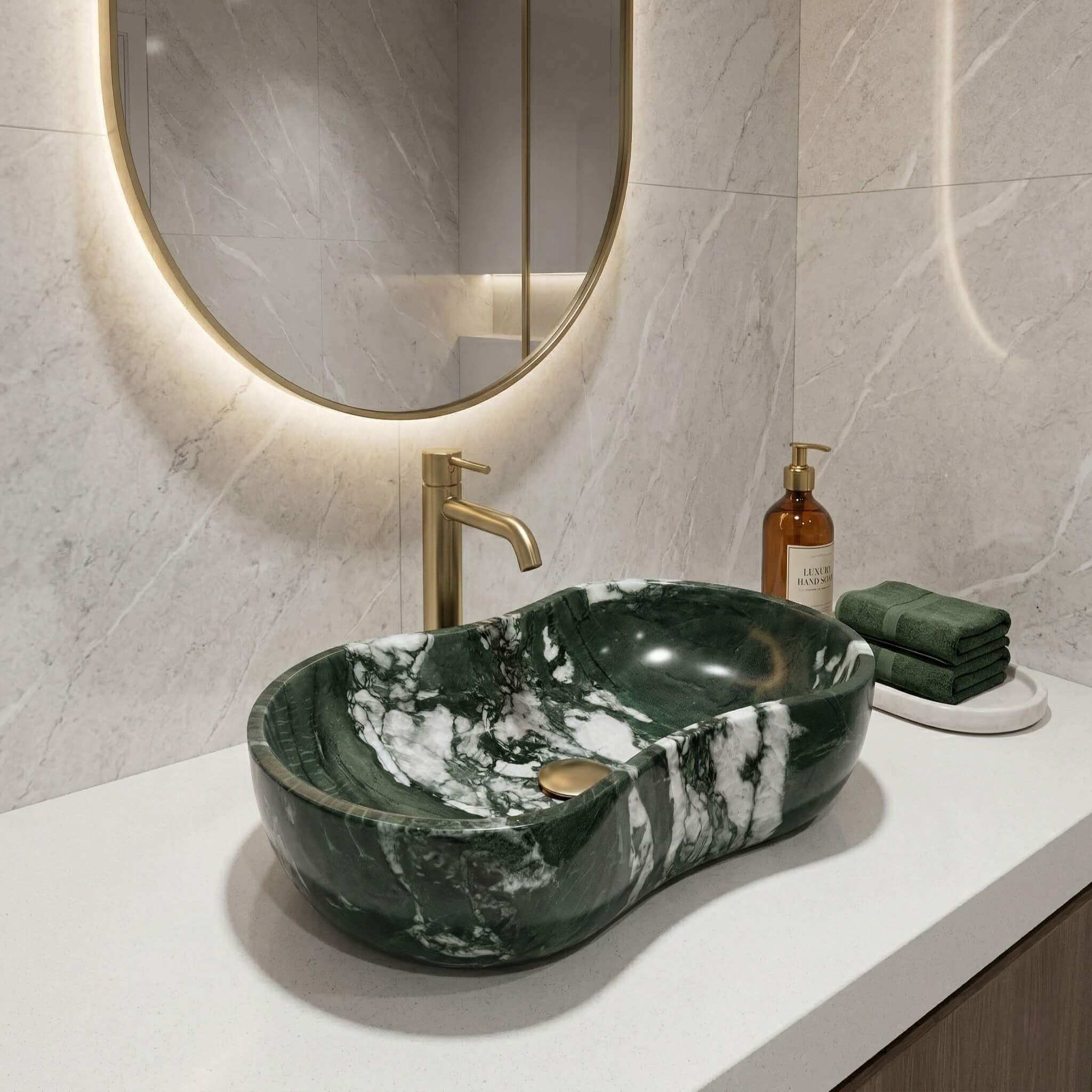 Luxury master bathroom featuring a Diamond Green marble wavy sink paired with a brushed gold faucet on a white quartz countertop with a backlit mirror.