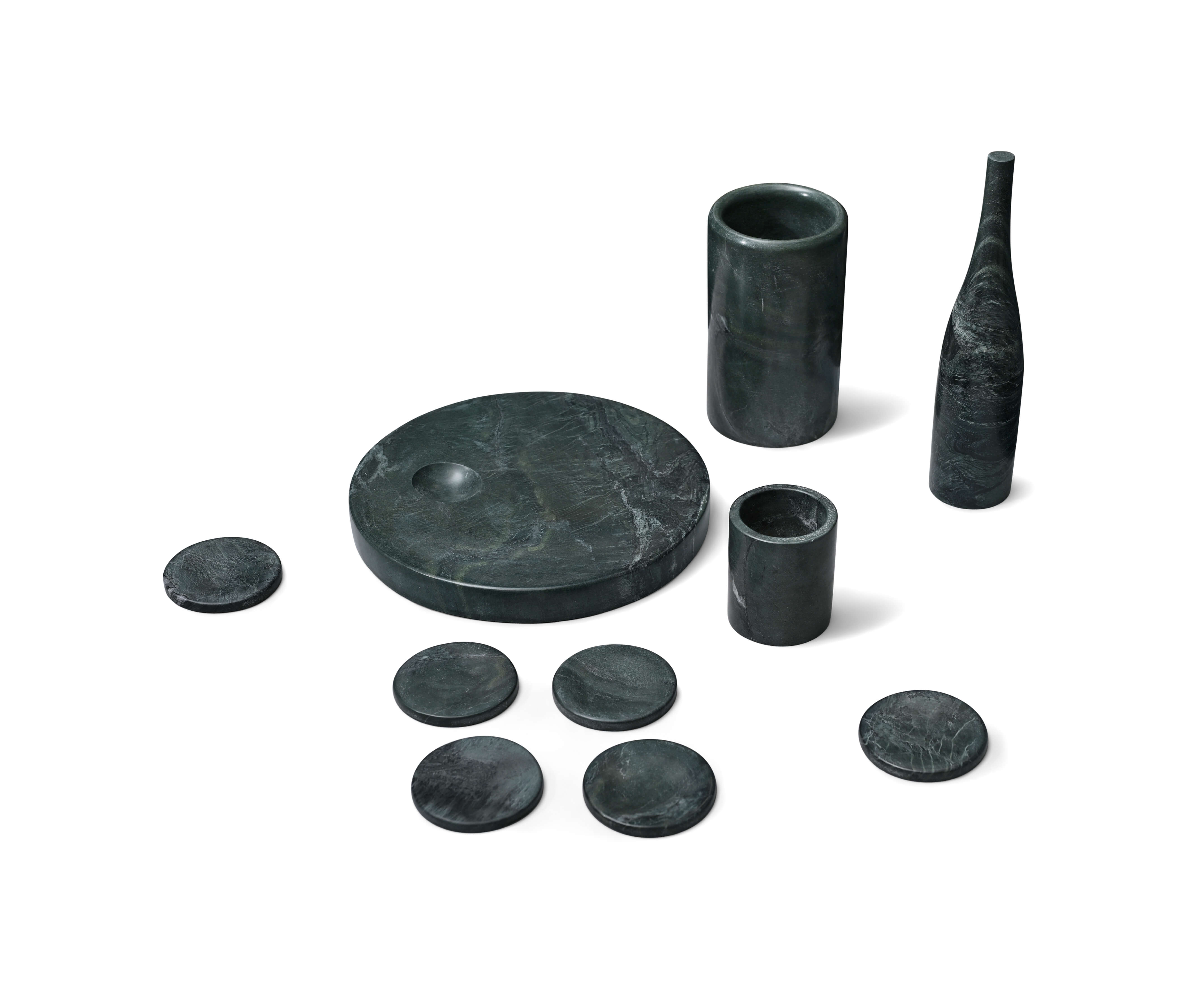 Close-up of matte finish forest green marble home decor items including a tall sculptural vase and a bottle chiller.