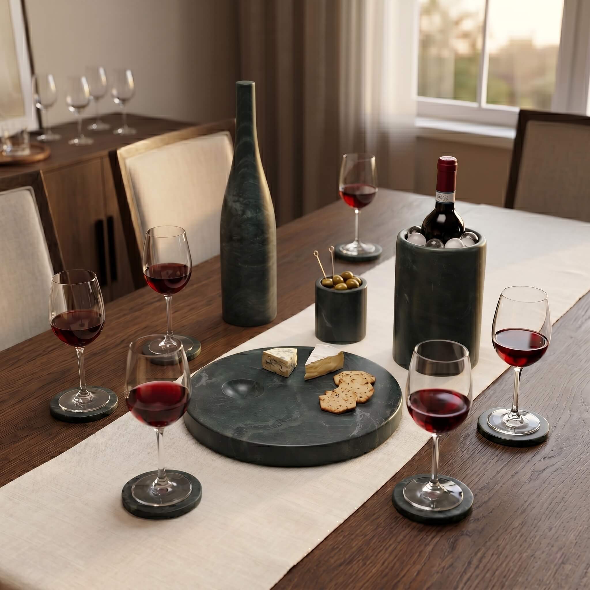 Sophisticated dining setup featuring green marble wine cooler and round tray on a dark wood table with beige runner.