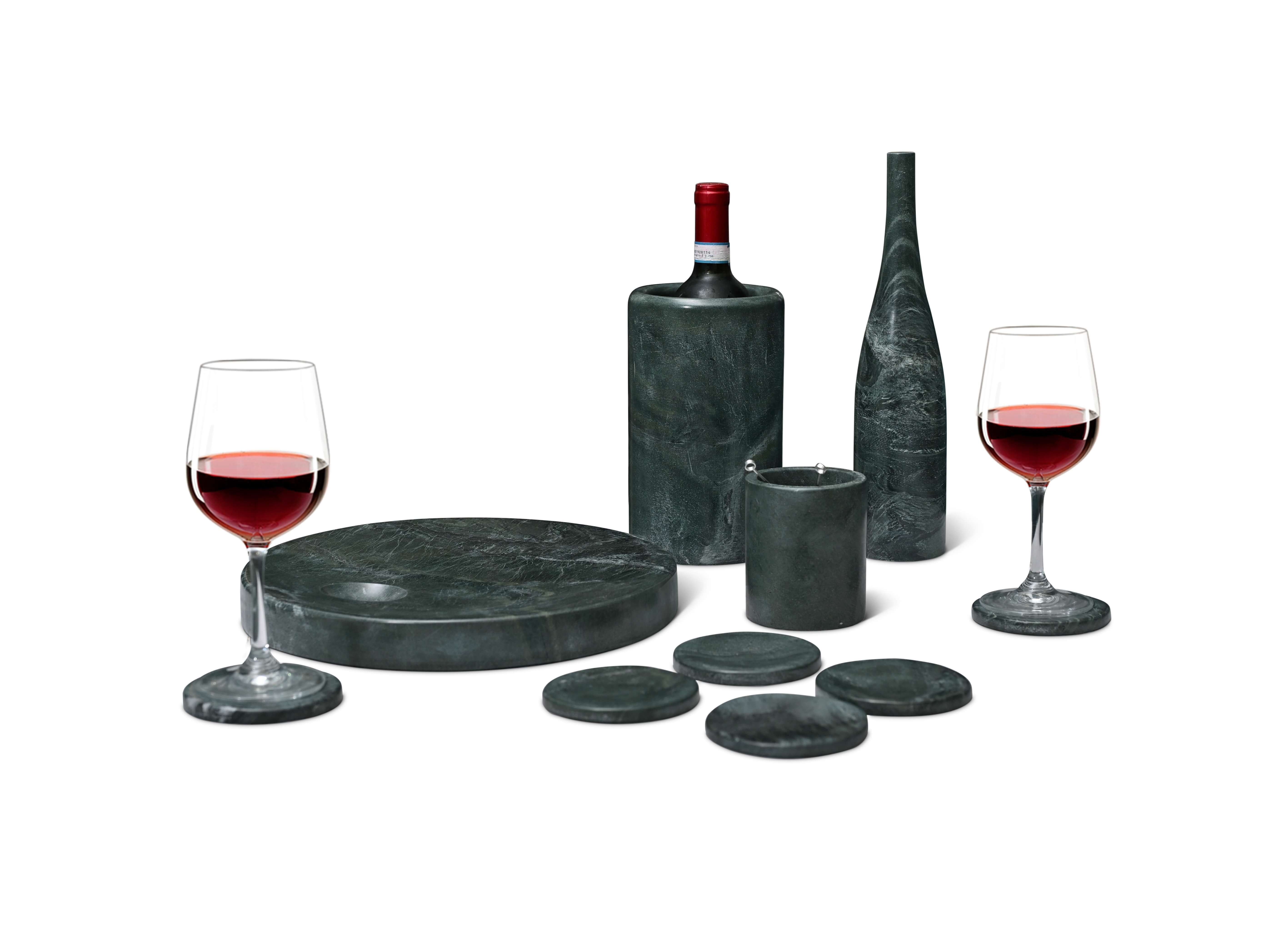 Professional display of a honed-finish Diamond Green marble 10-piece set including a sculptural vase, wine cooler, and serving platter.