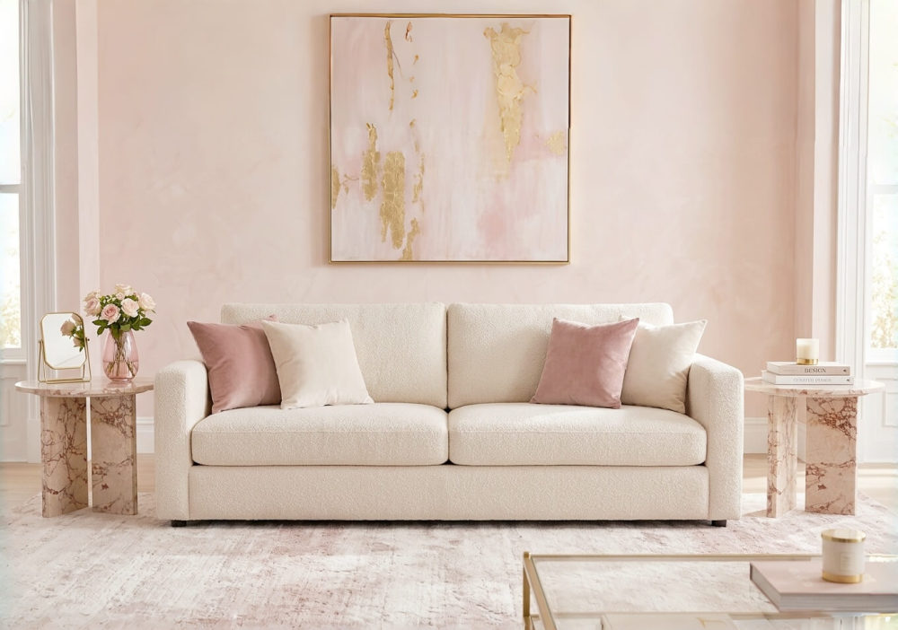 Pair of Diamond Pink natural marble side tables used as matching sofa end tables in a French romantic blush pink living room — cream boucle sofa, rose gold abstract wall art, pink roses and gold mirror as tabletop styling.