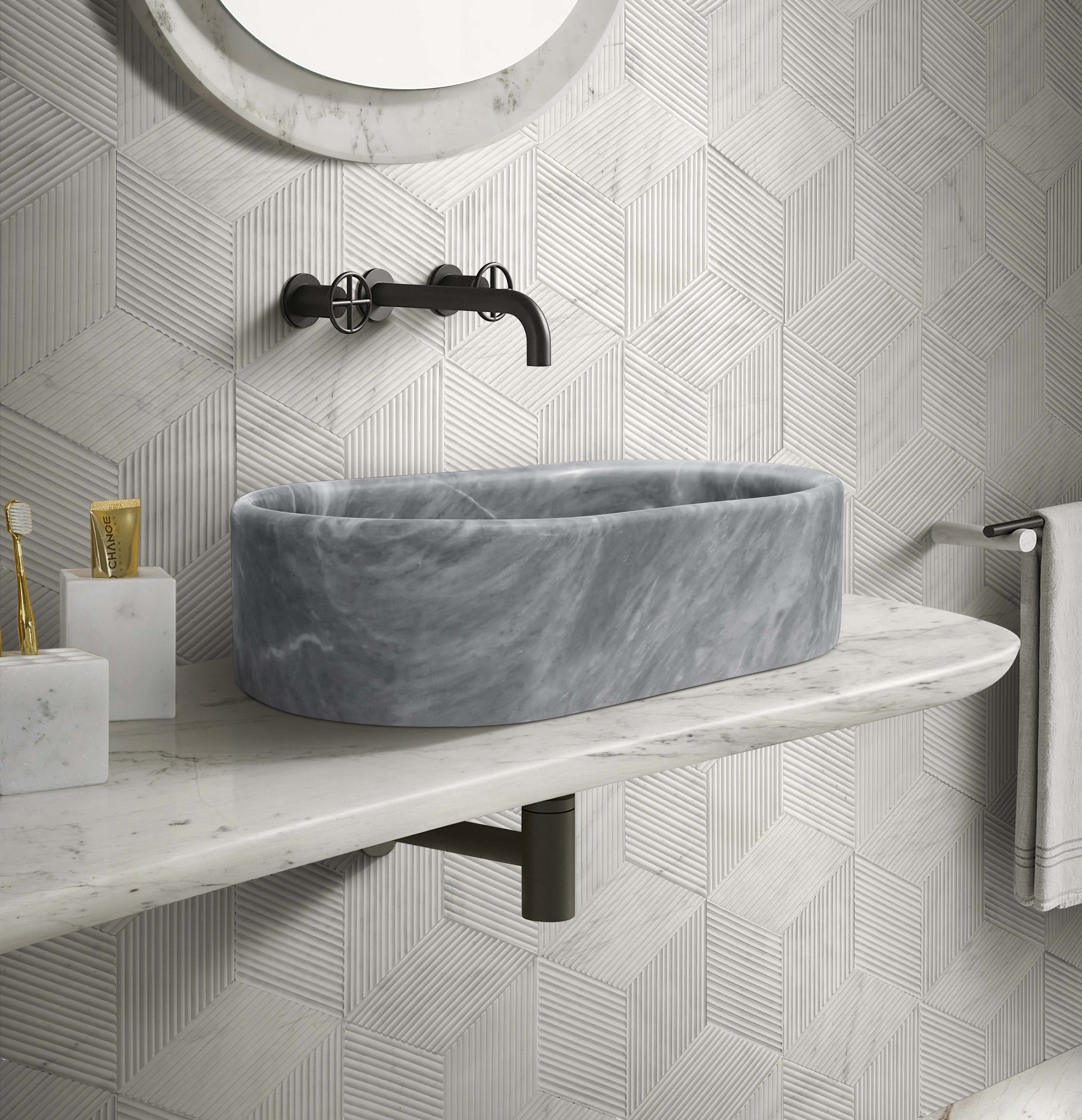 Carrara gray marble vessel sink in powder room with snow mountain white hexagon textured tile and black wall faucet.