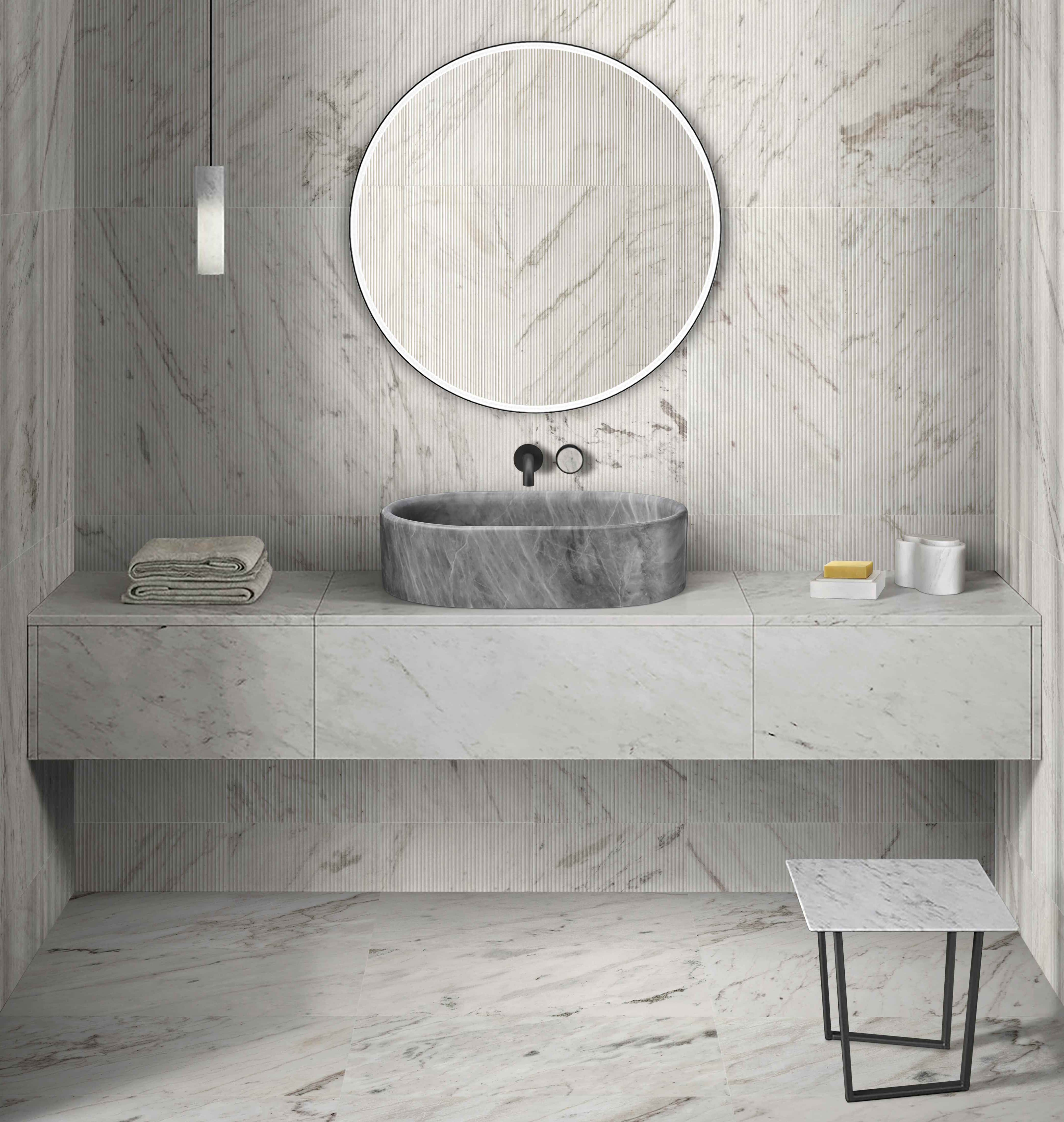 Carrara gray marble vessel sink paired with snow mountain white textured wall tile and matching marble accessory set.