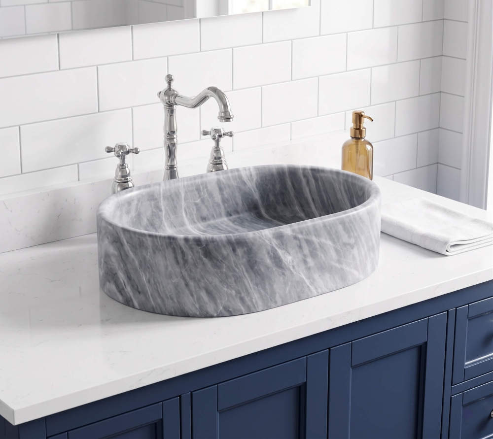 Oval Carrara gray marble vessel sink on white quartz over navy blue shaker vanity with chrome bridge faucet, subway tile.