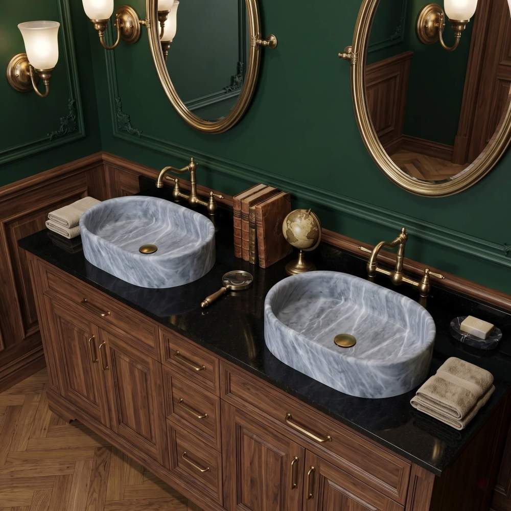 Two oval Carrara gray marble vessel sinks on a walnut Victorian vanity with brass bridge faucets and forest green walls.