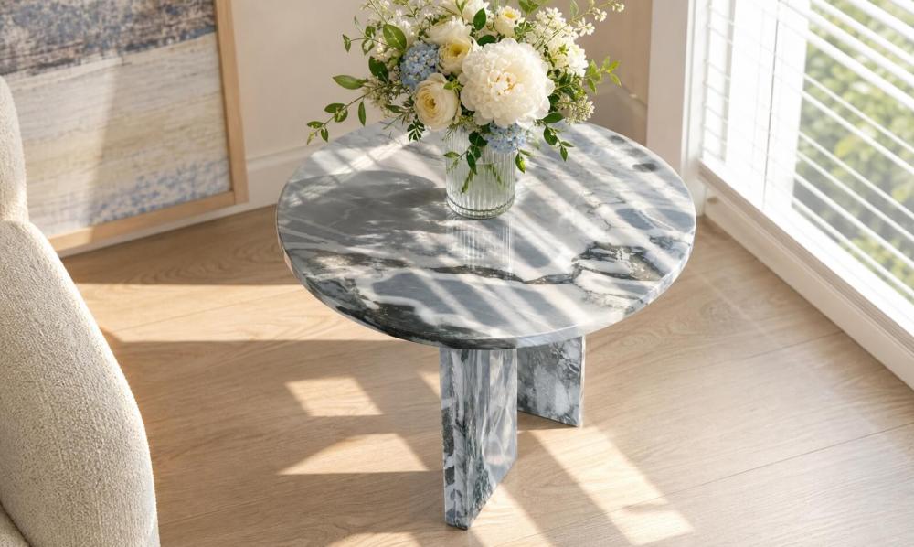 Cloudy blue marble side table topped with white peony, blue hydrangea, and rose bouquet in ribbed glass vase by sunlit window.