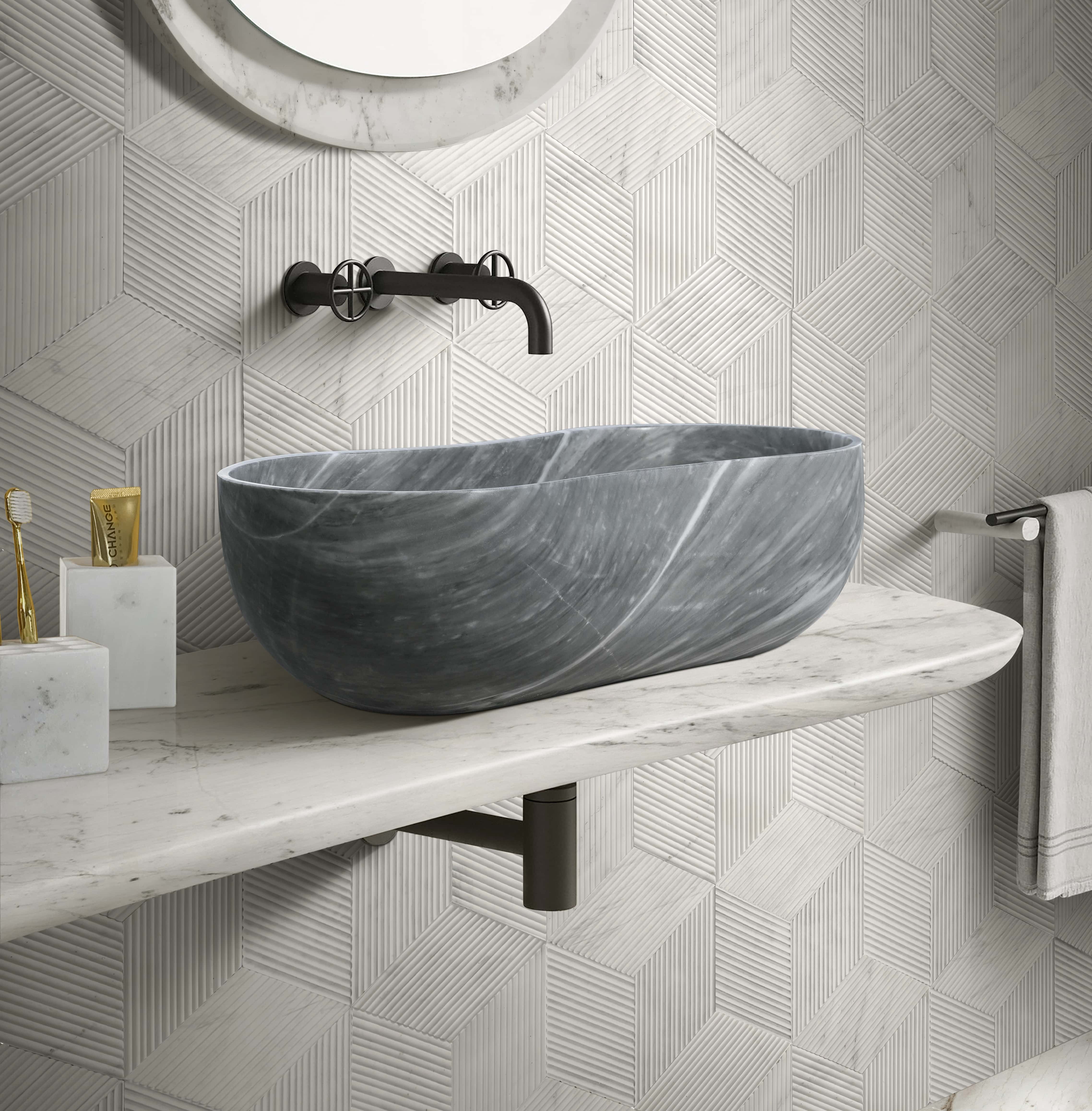 Carrara gray marble vessel sink with snow mountain white hexagon textured wall tiles and matching honed marble bathroom accessories.