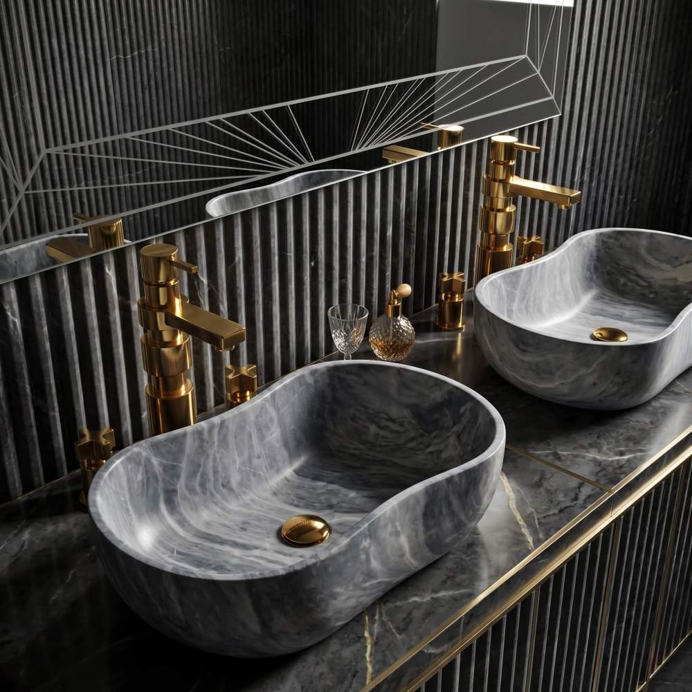 Carrara gray marble vessel sinks paired with brushed gold faucets against fluted dark marble wall in a luxurious Art Deco bathroom setting.