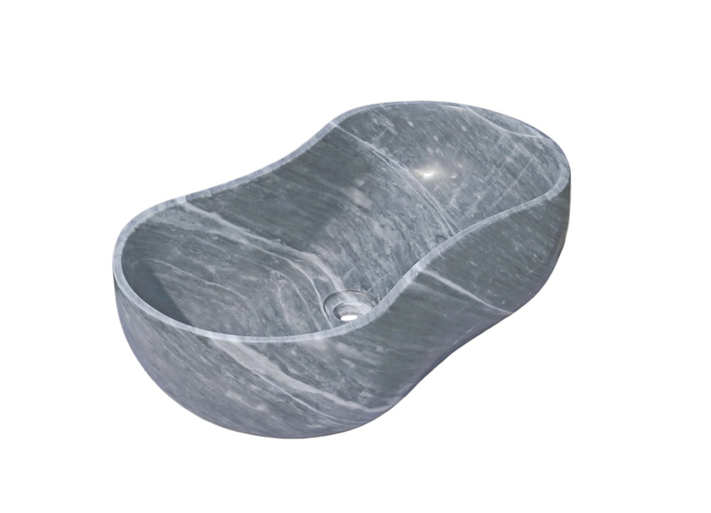 High-angle view of Carrara gray marble vessel sink with wavy peanut silhouette, hand-honed finish and soft vertical white veining across the basin.