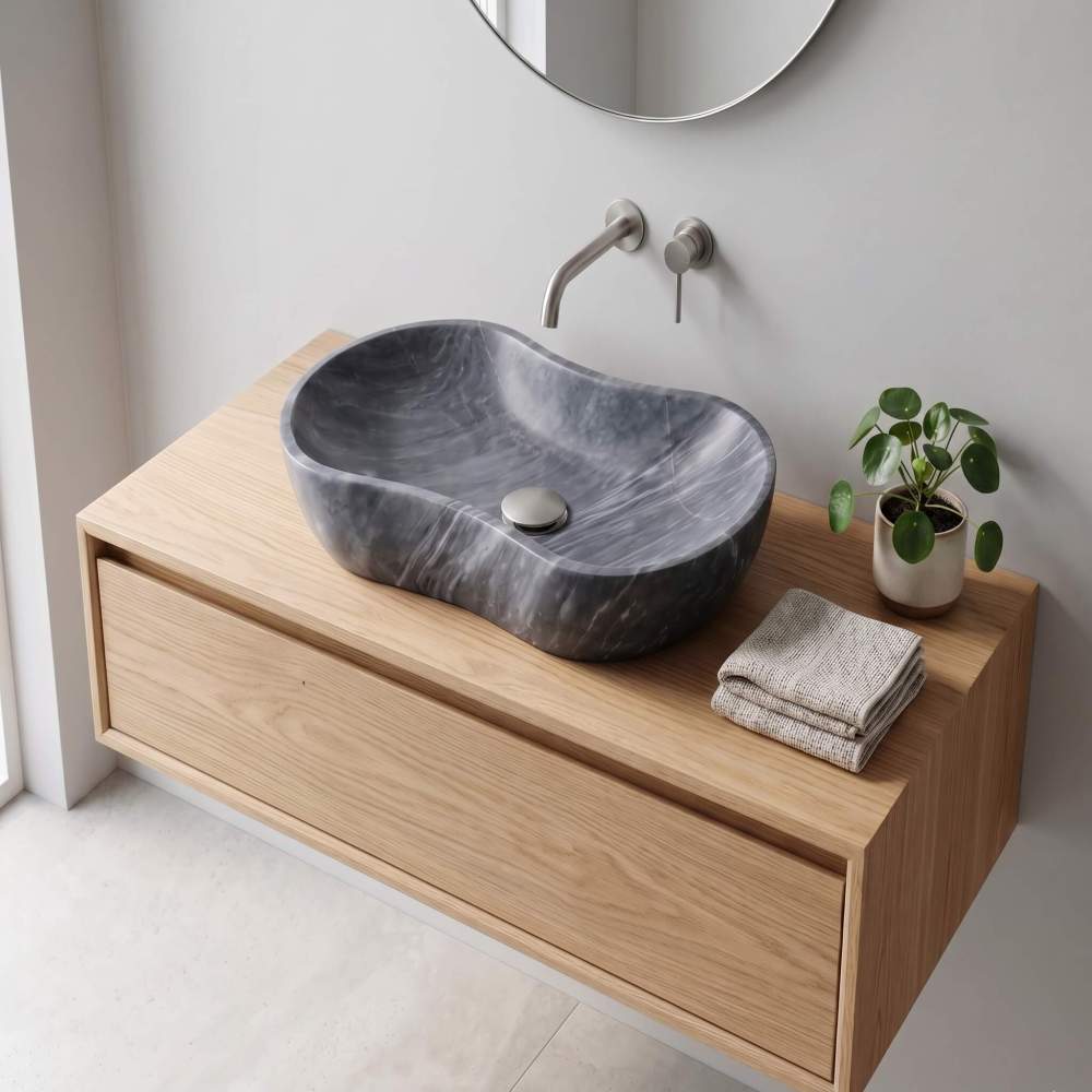 Carrara gray marble vessel sink on light oak floating vanity with brushed nickel wall-mount faucet in a Japandi Scandinavian zen bathroom.