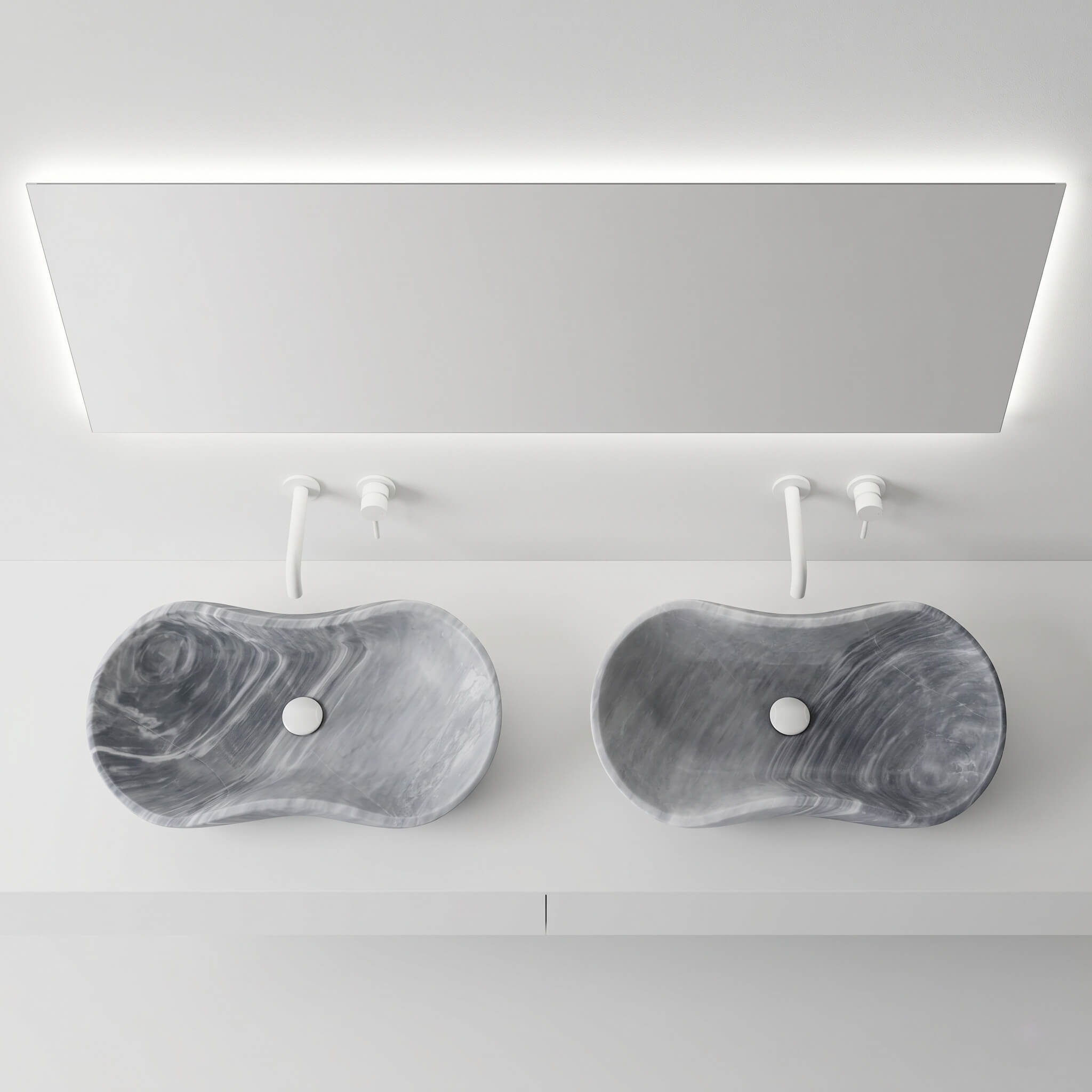Overhead view of two Carrara gray marble vessel sinks with white wall-mount faucets and backlit mirror in an ultra-minimalist gallery-style bathroom.