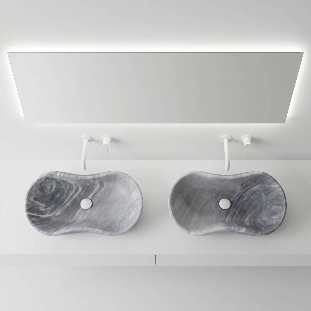Overhead view of two Carrara gray marble vessel sinks with white wall-mount faucets and backlit mirror in an ultra-minimalist gallery-style bathroom.