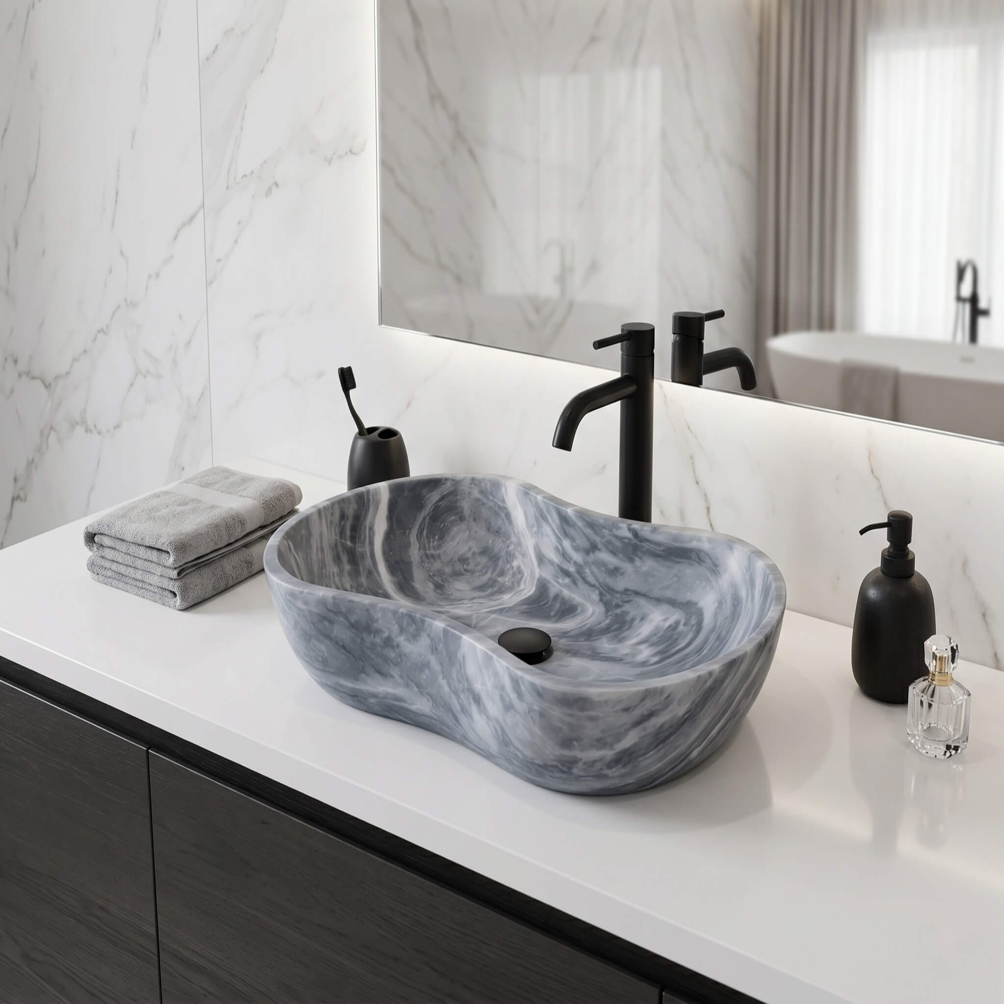 Carrara gray marble vessel sink with matte black faucet on white quartz counter against Calacatta marble wall in a modern master bathroom.