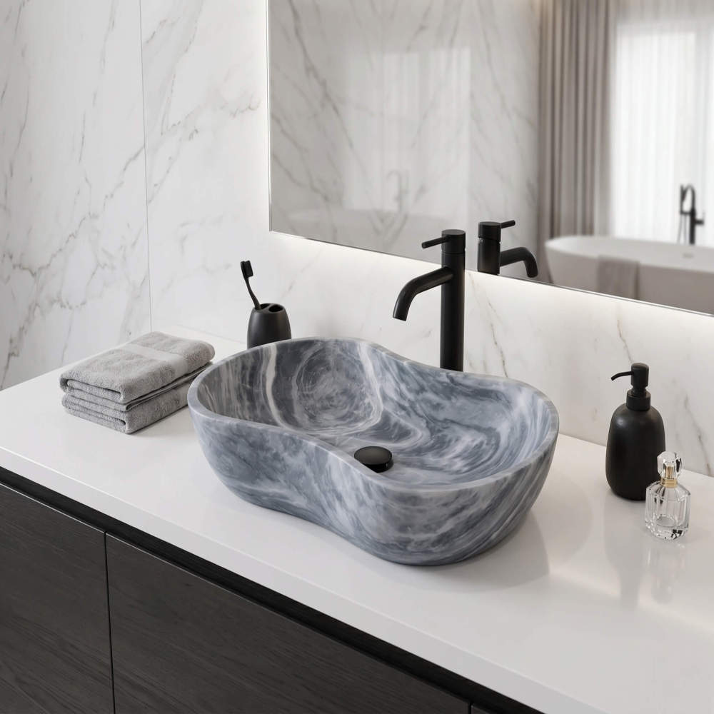 Carrara gray marble vessel sink with matte black faucet on white quartz counter against Calacatta marble wall in a modern master bathroom.