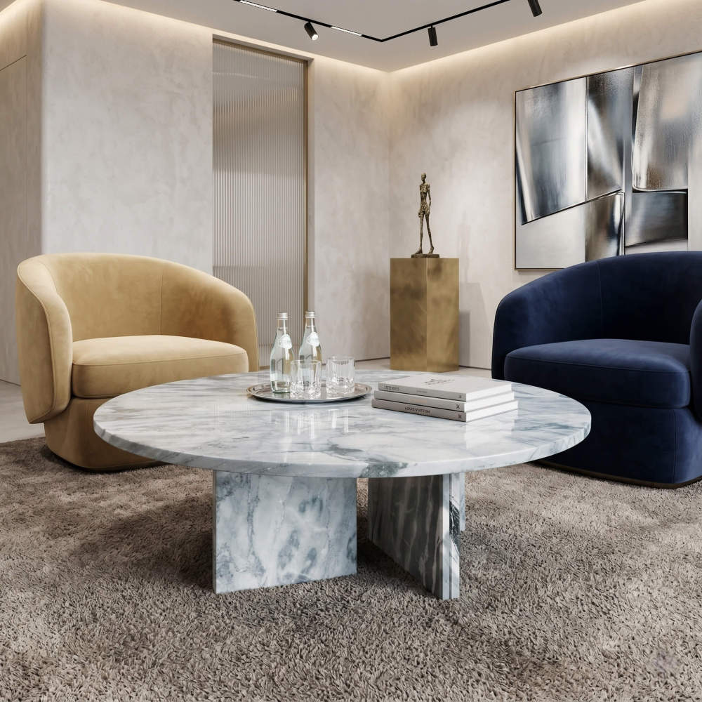 Cloudy blue marble coffee table in contemporary luxe lounge with mustard and navy velvet armchairs, brass sculpture, and abstract art.