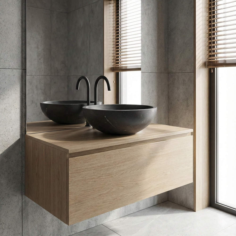 Black marble vessel sink on floating oak vanity, large-format concrete tile walls and matte black faucet in modern bathroom.