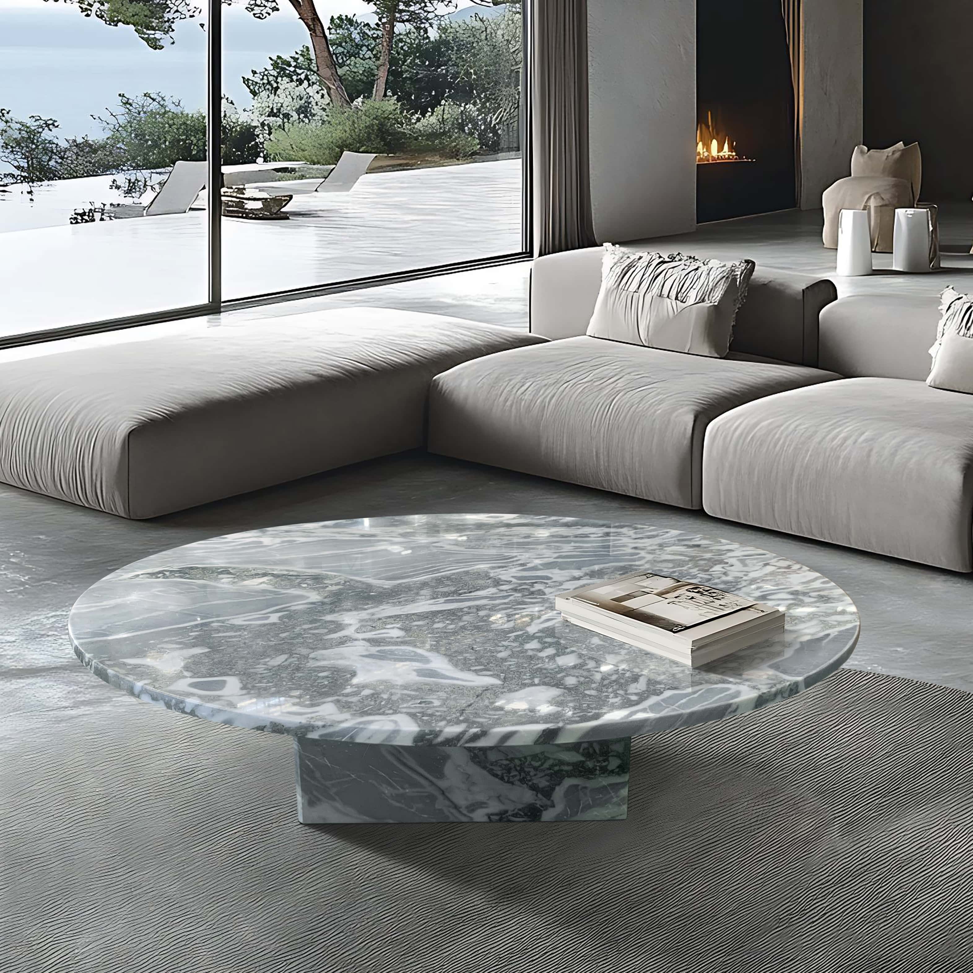 Cloudy blue marble coffee table in coastal living room with low-profile sofa, fireplace, and ocean view.