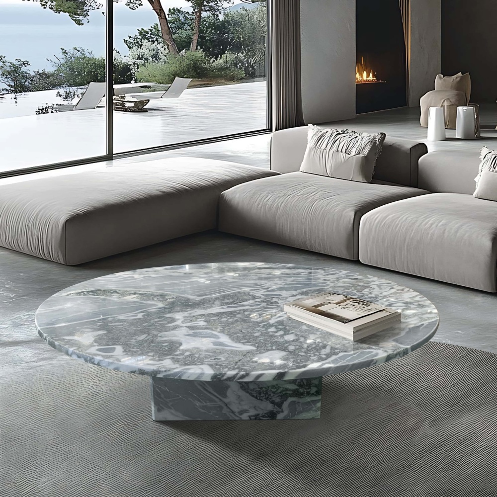 Cloudy blue marble coffee table in coastal living room with low-profile sofa, fireplace, and ocean view.