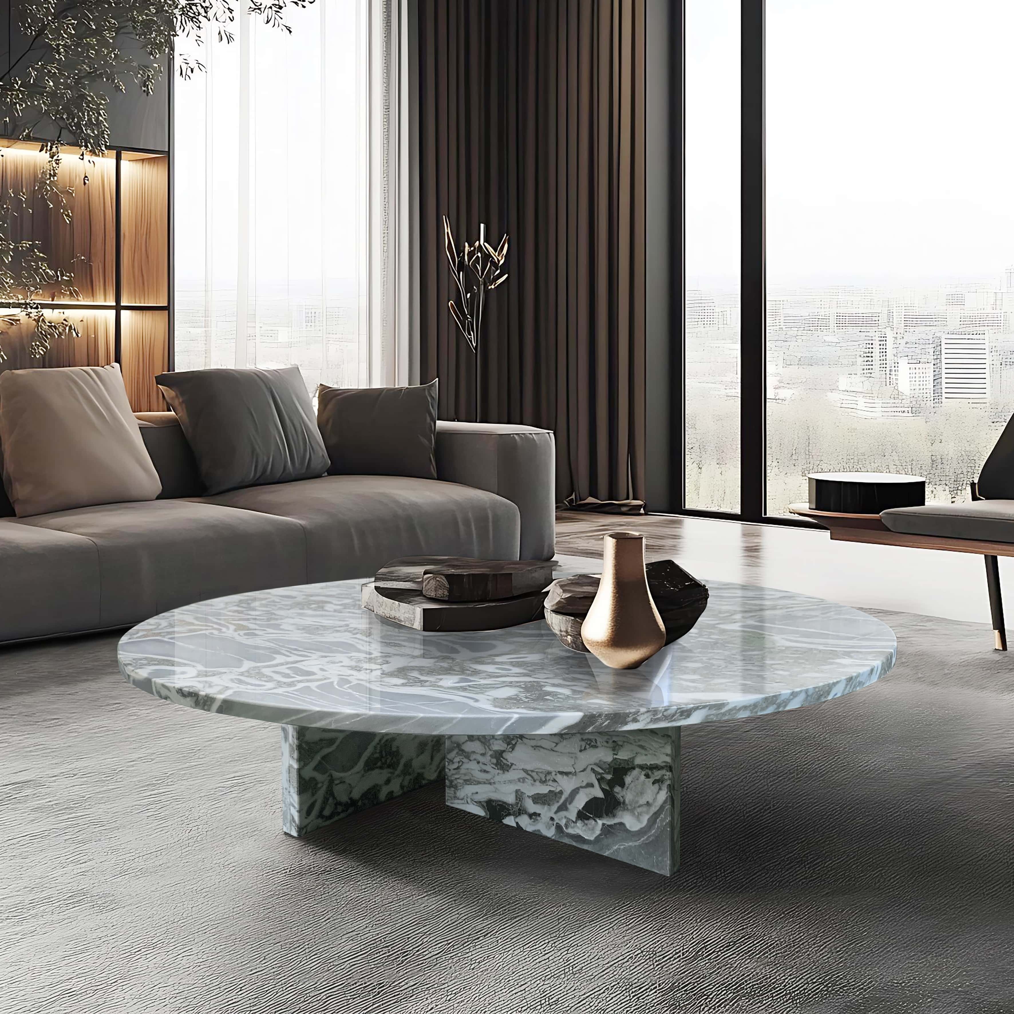 Cloudy blue marble coffee table in modern minimalist living room with curved gray sofa and floor-to-ceiling windows.