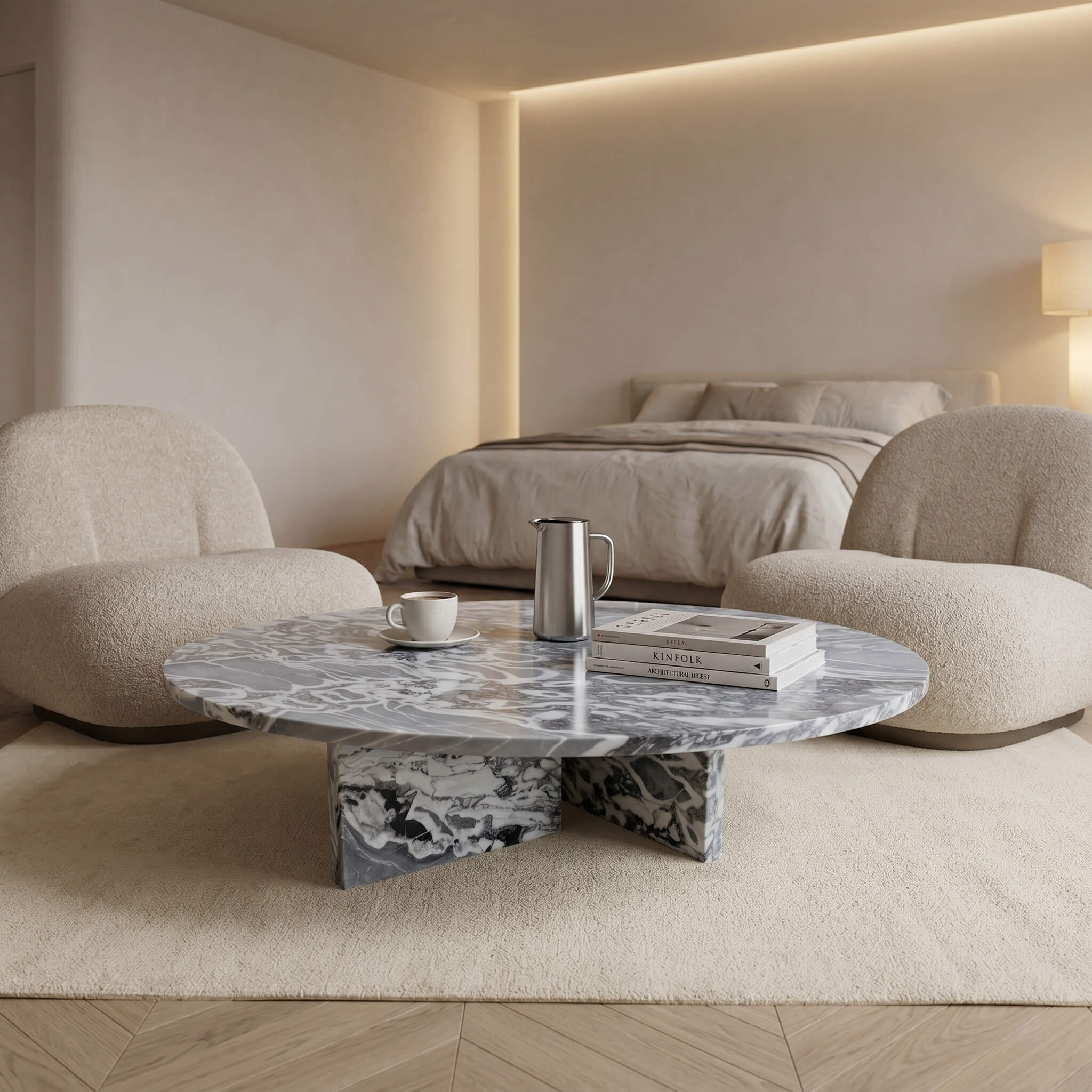 Cloudy blue marble coffee table in quiet luxury bedroom sitting area with boucle armchairs and herringbone wood floor.