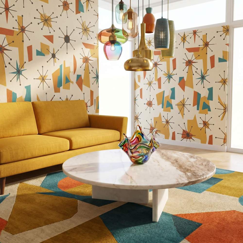 Round white marble coffee table in a retro room with mustard sofa, atomic-print wallpaper, and colorful pendant lights.