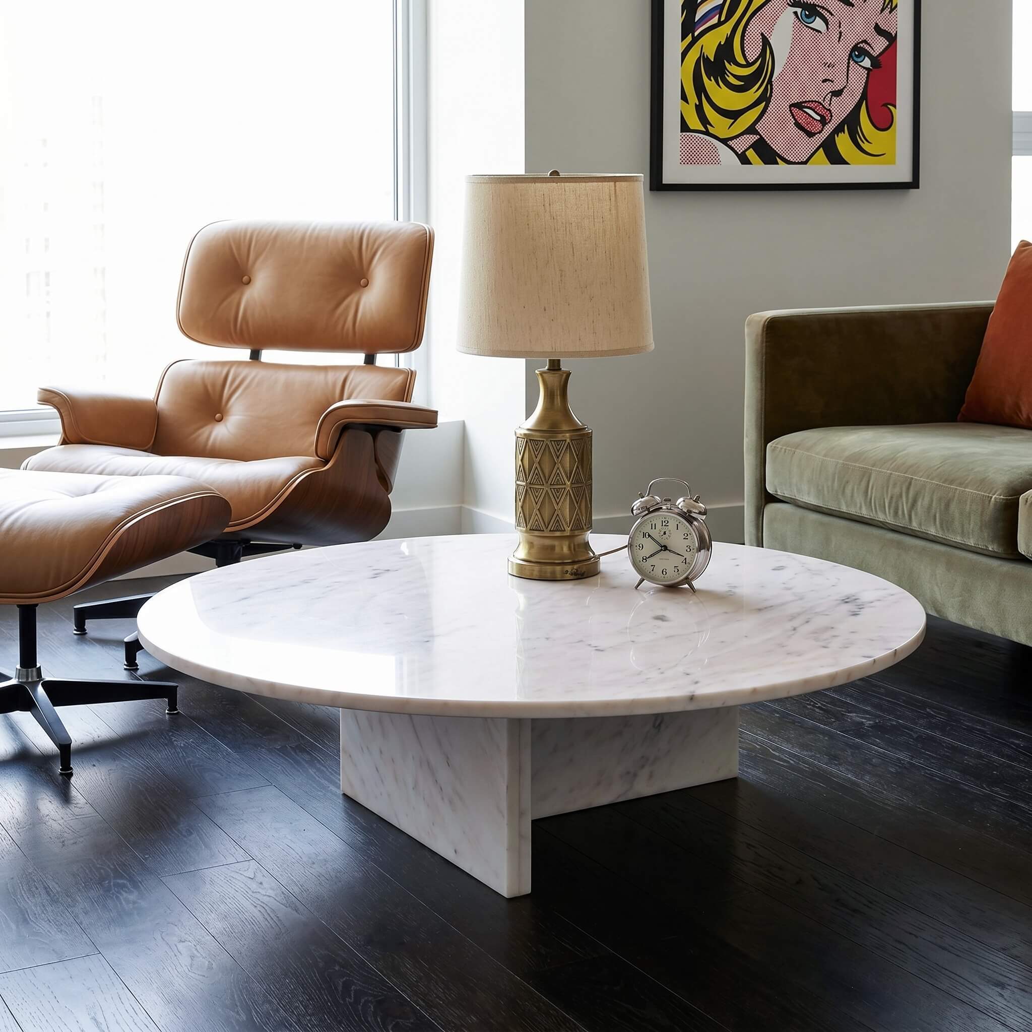 Round white marble coffee table in a mid-century room with tan leather lounge chair, olive sofa, brass lamp, and pop-art print.