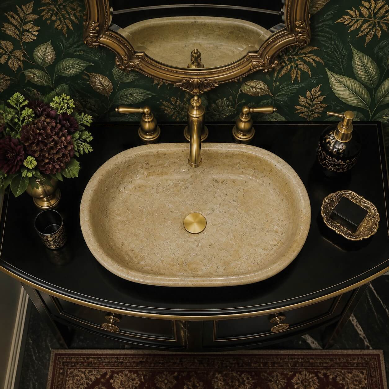 Amber Gold marble vessel sink on curved black vanity with antique brass faucet, dark botanical wallpaper, and ornate gold-framed mirror overhead.