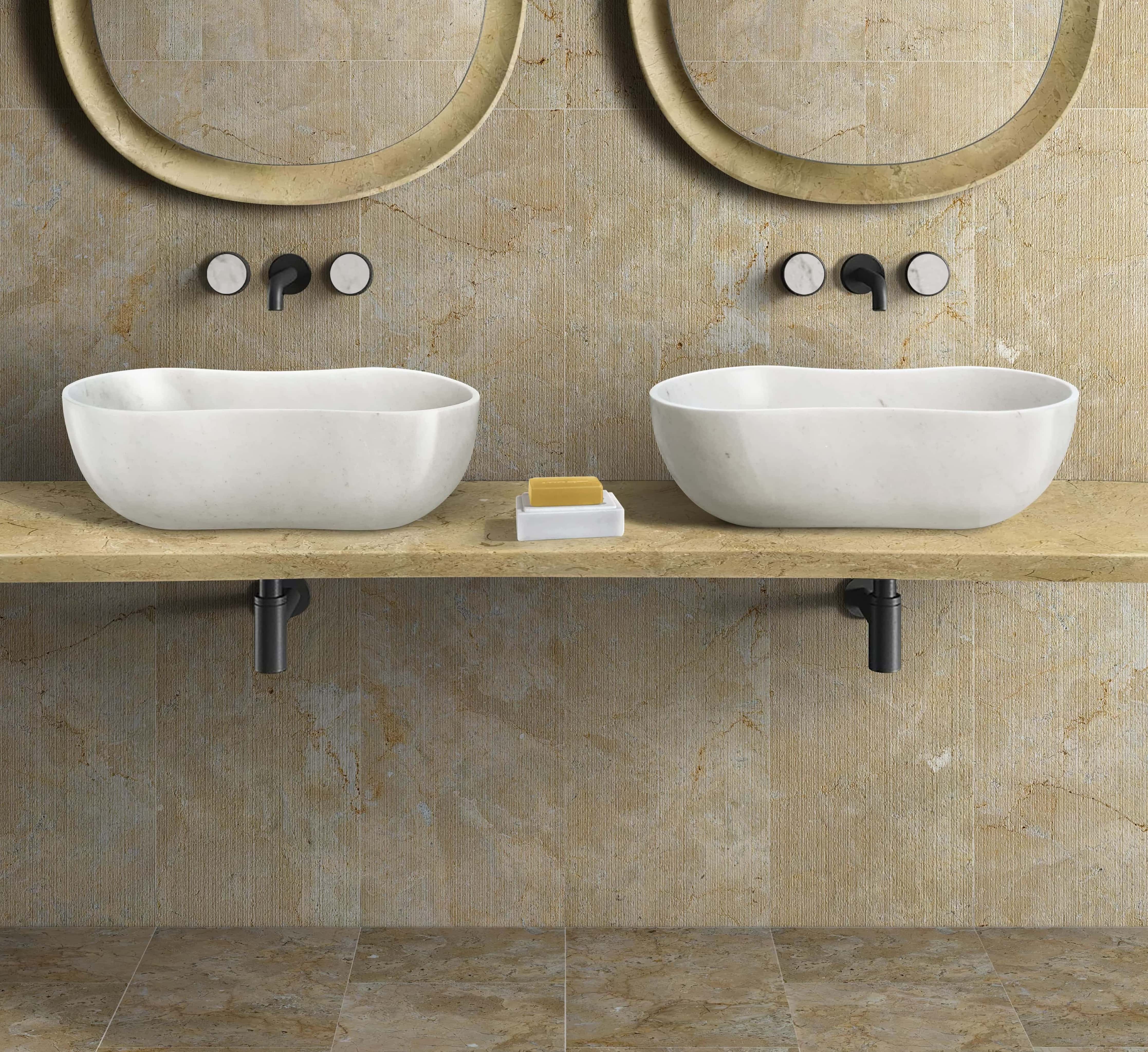 Double Snow Mountain White honed wavy marble vessel sinks on a Gold floating stone shelf , featuring 12x24 Hyatt Gold polished tile flooring and 12x24 FS textured tile wall coverings with matte black fixtures.