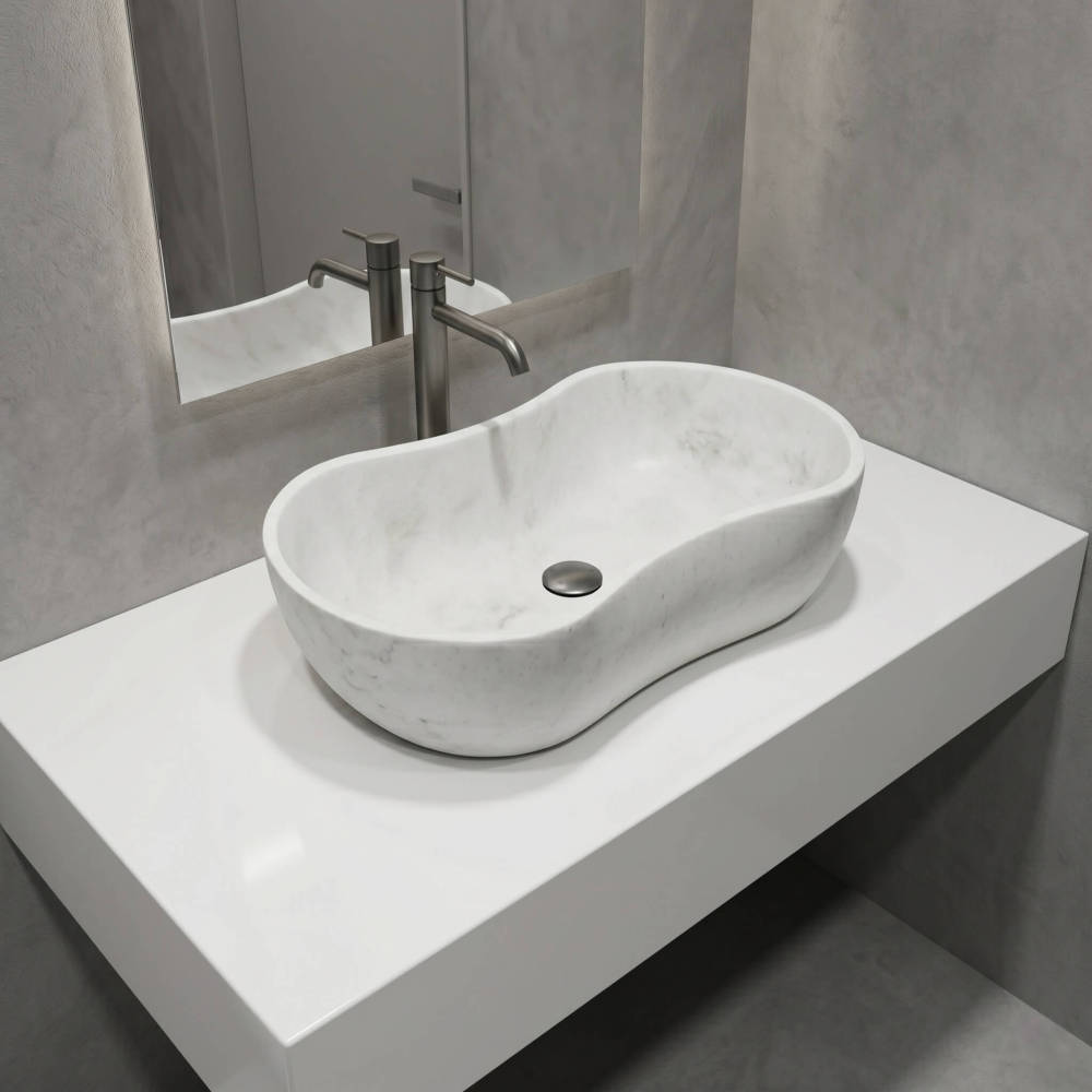 A high-angle 3/4 view of the wavy marble vessel sink on a clean white floating vanity against concrete-textured walls. Features a silver faucet and round drain stopper. Modern minimalist style.