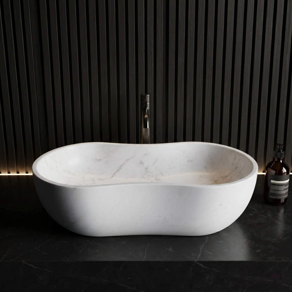 Front view of the Snow Mountain White wavy marble vessel sink on a black marble counter against a dark vertical slat wall. Paired with a sleek dark faucet and amber glass soap bottle. Industrial design aesthetic.