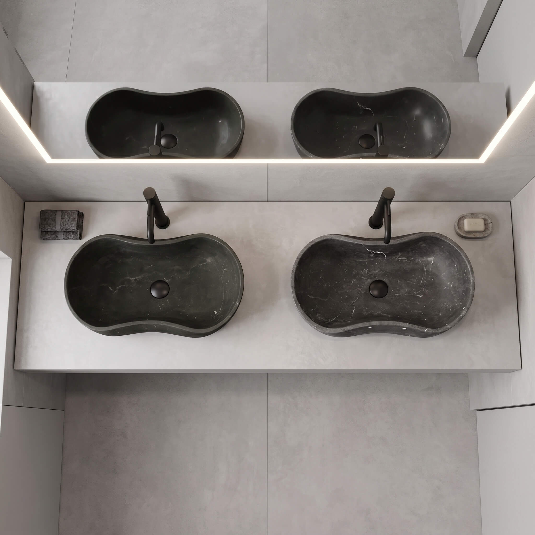 An overhead, top-down perspective of two honed Olive Black marble vessel sinks installed with matte black faucets on a modern light gray countertop.