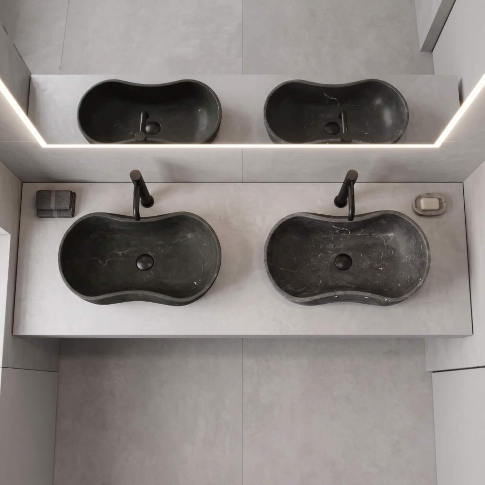 An overhead, top-down perspective of two honed Olive Black marble vessel sinks installed with matte black faucets on a modern light gray countertop.