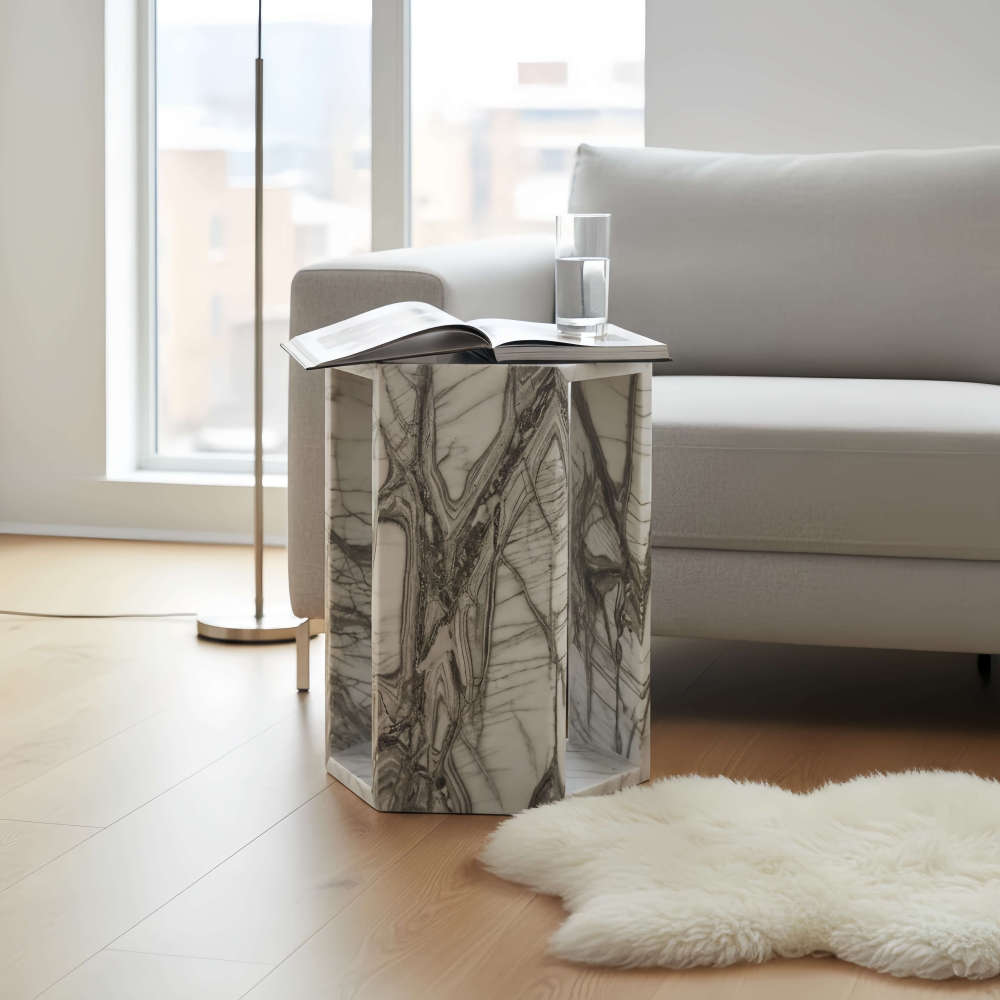 Arboris White natural marble side table with an open book on top beside a white sheepskin rug.