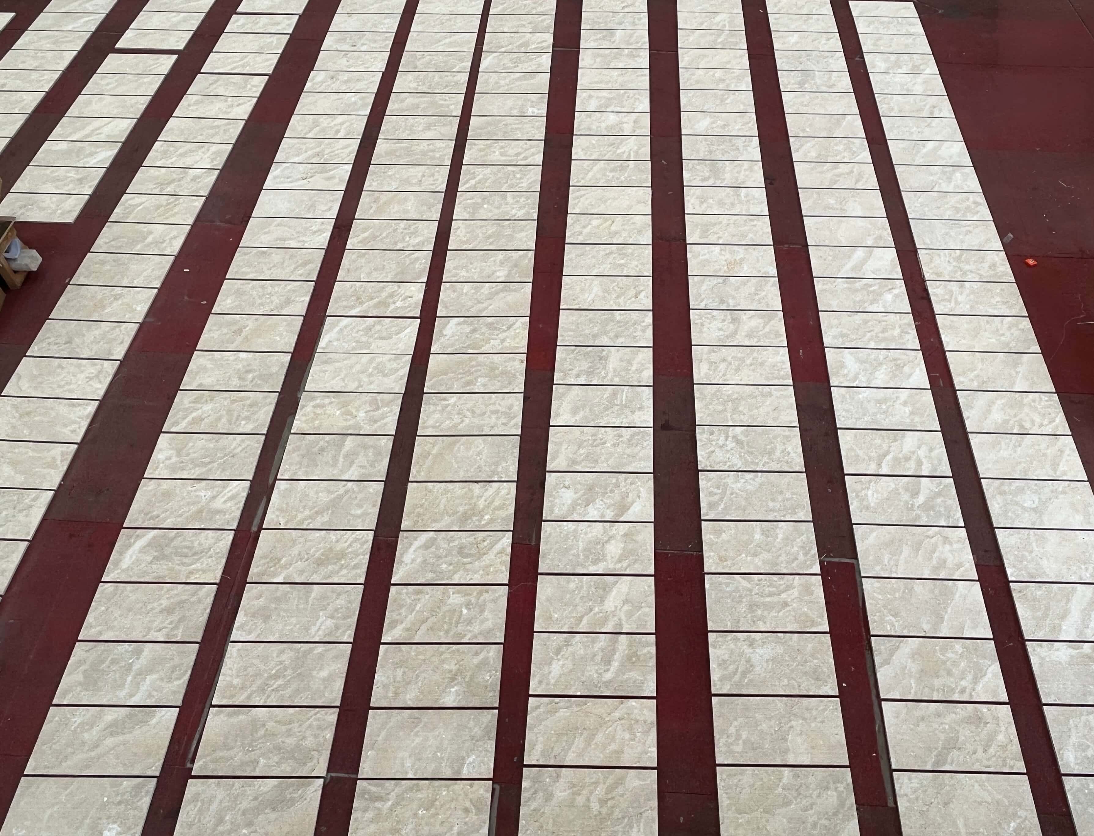Factory dry lay inspection of Amber Gold natural marble wall tiles arranged in rows for quality control and color matching.